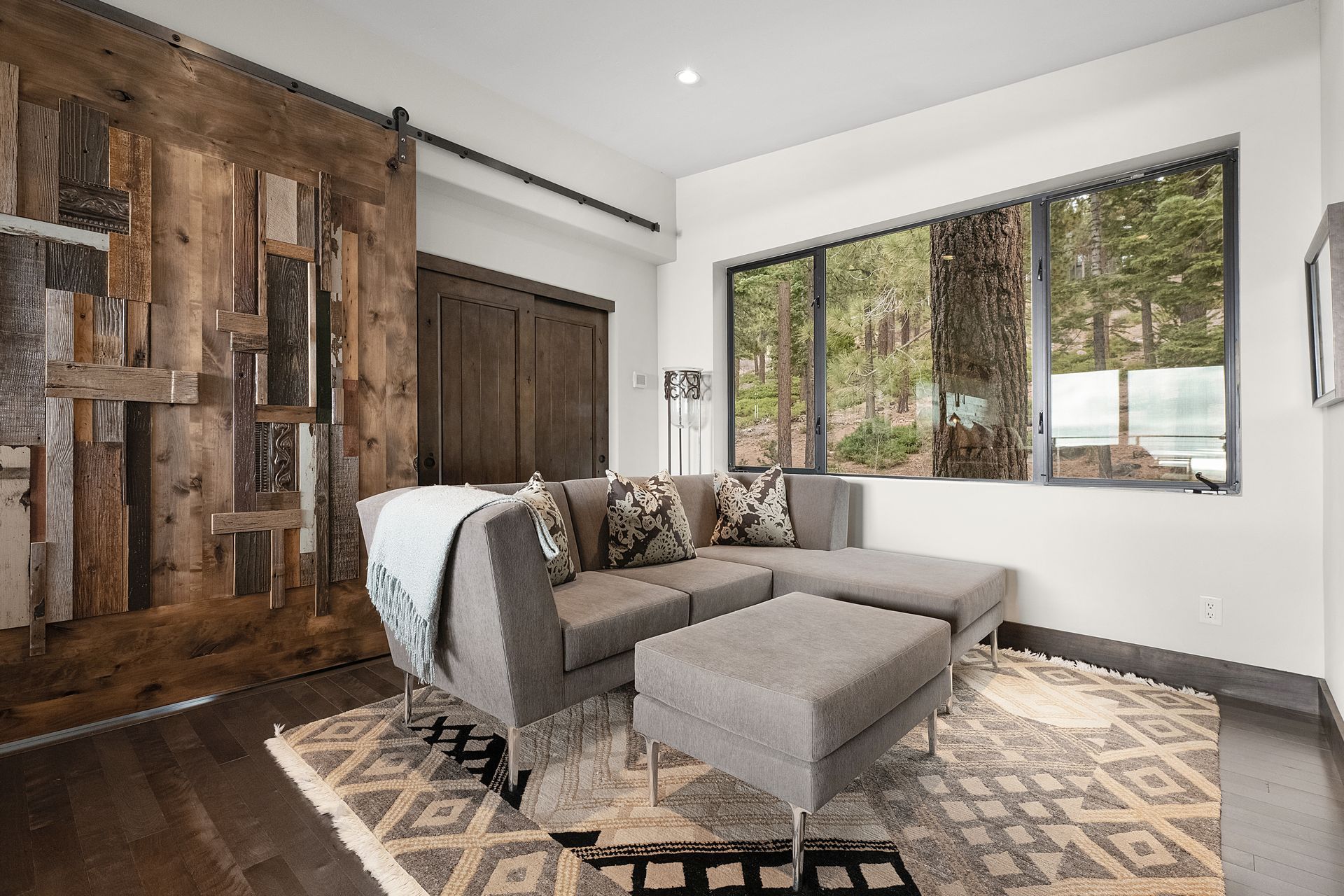 a living room with a couch and chairs and a sliding barn door