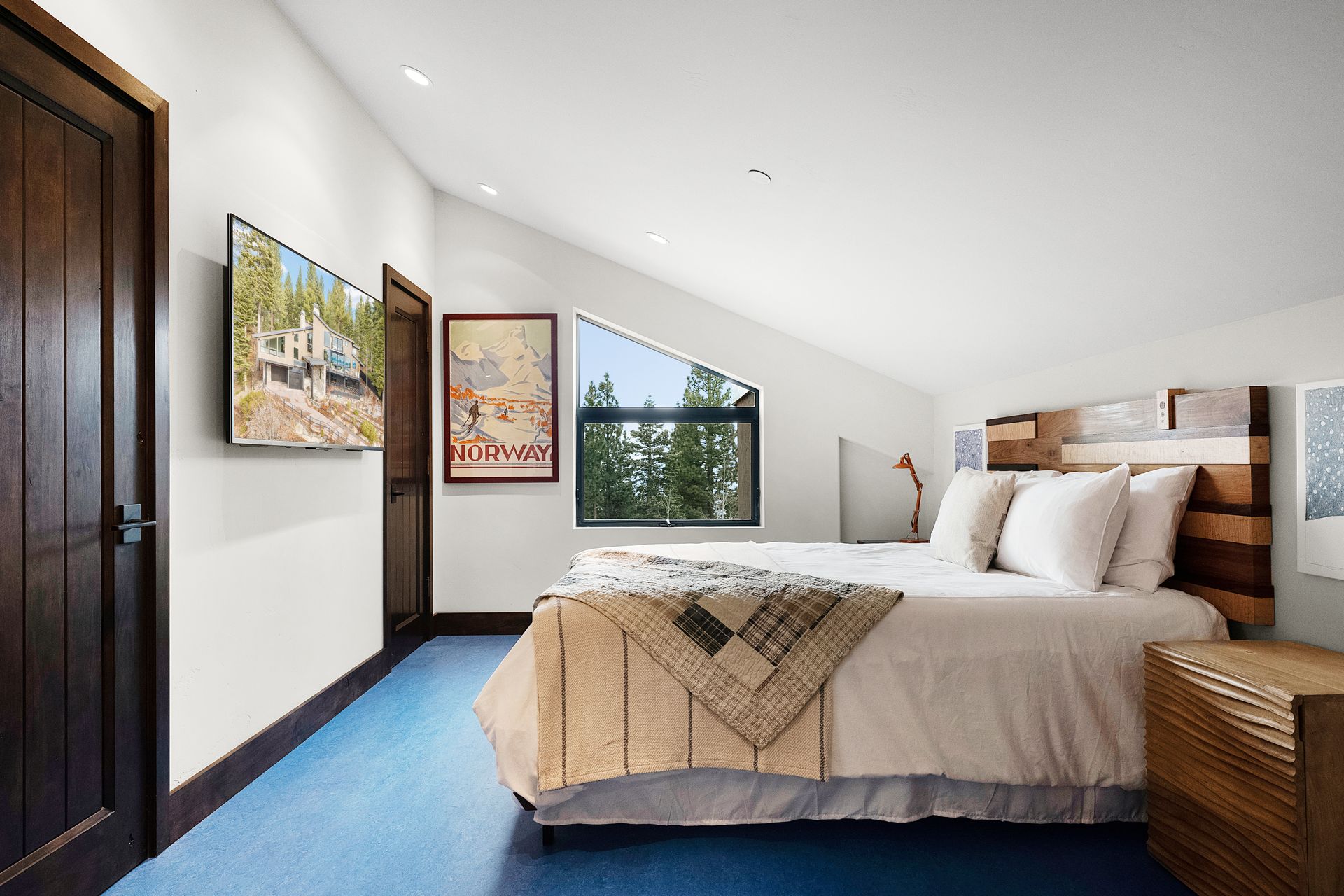 a bedroom with a bed and a television on the wall