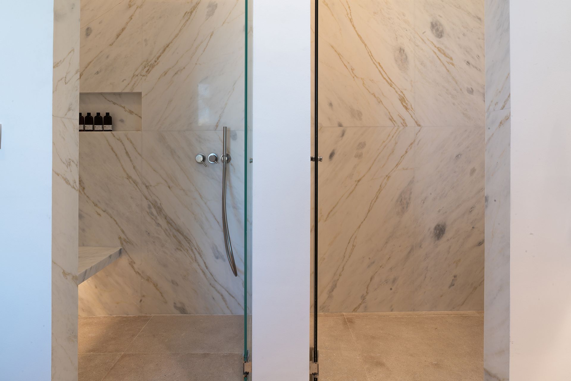a bathroom with a walk in shower and a glass door