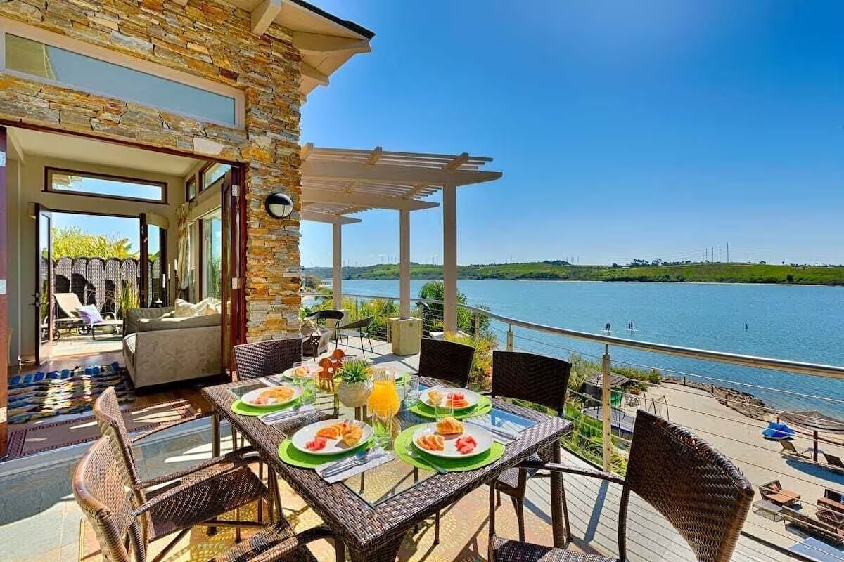 a patio with a table and chairs overlooking a lake