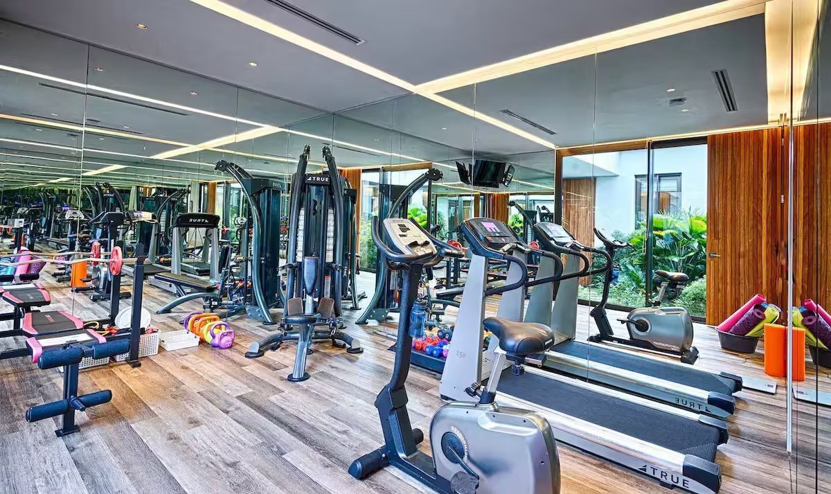 a home gym with a lot of exercise equipment and a large mirror