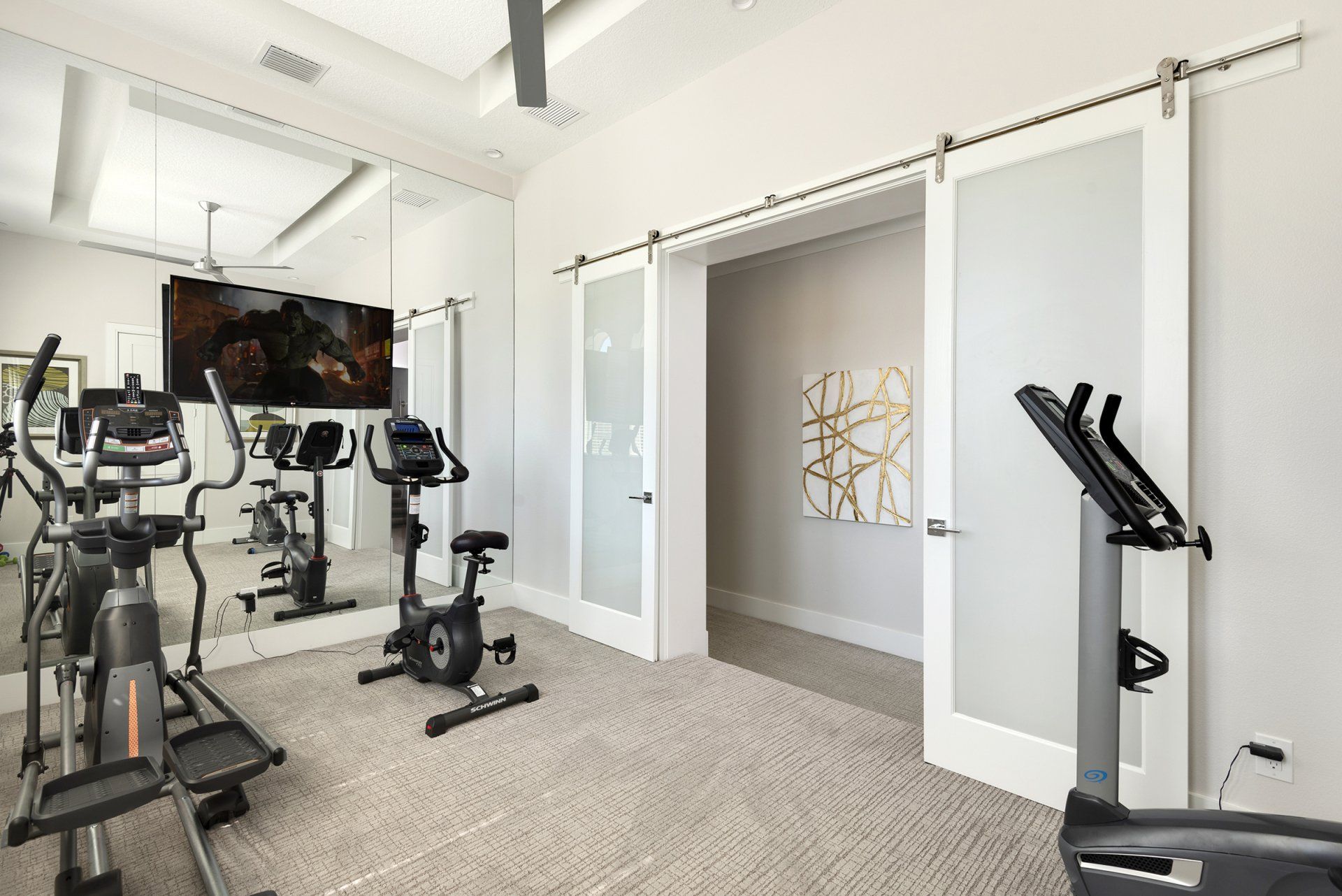 a home gym with a lot of exercise equipment and a large mirror