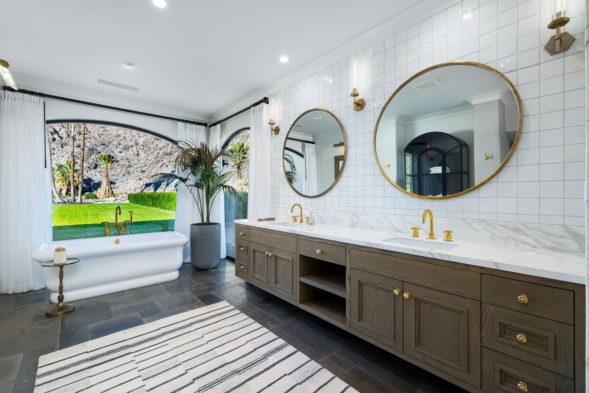 a bathroom with two sinks, two mirrors and wooden cabinets