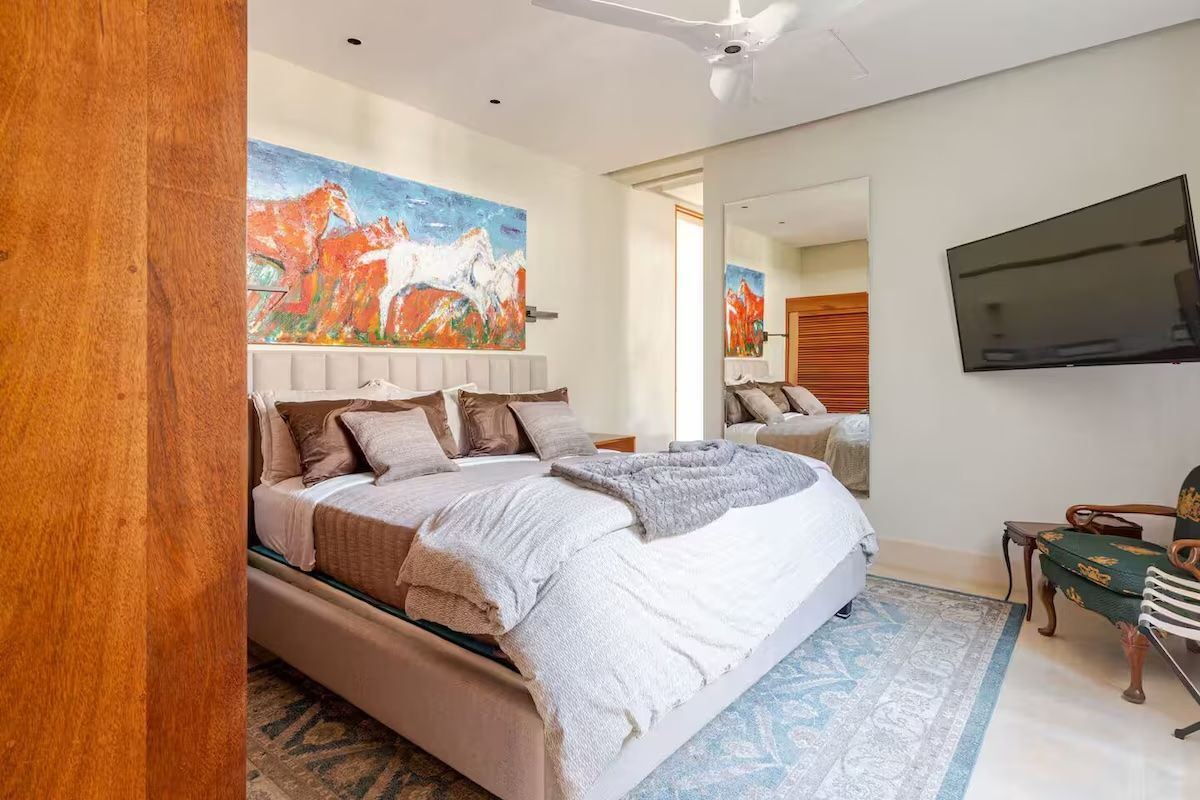 a bedroom with three bunk beds and a staircase