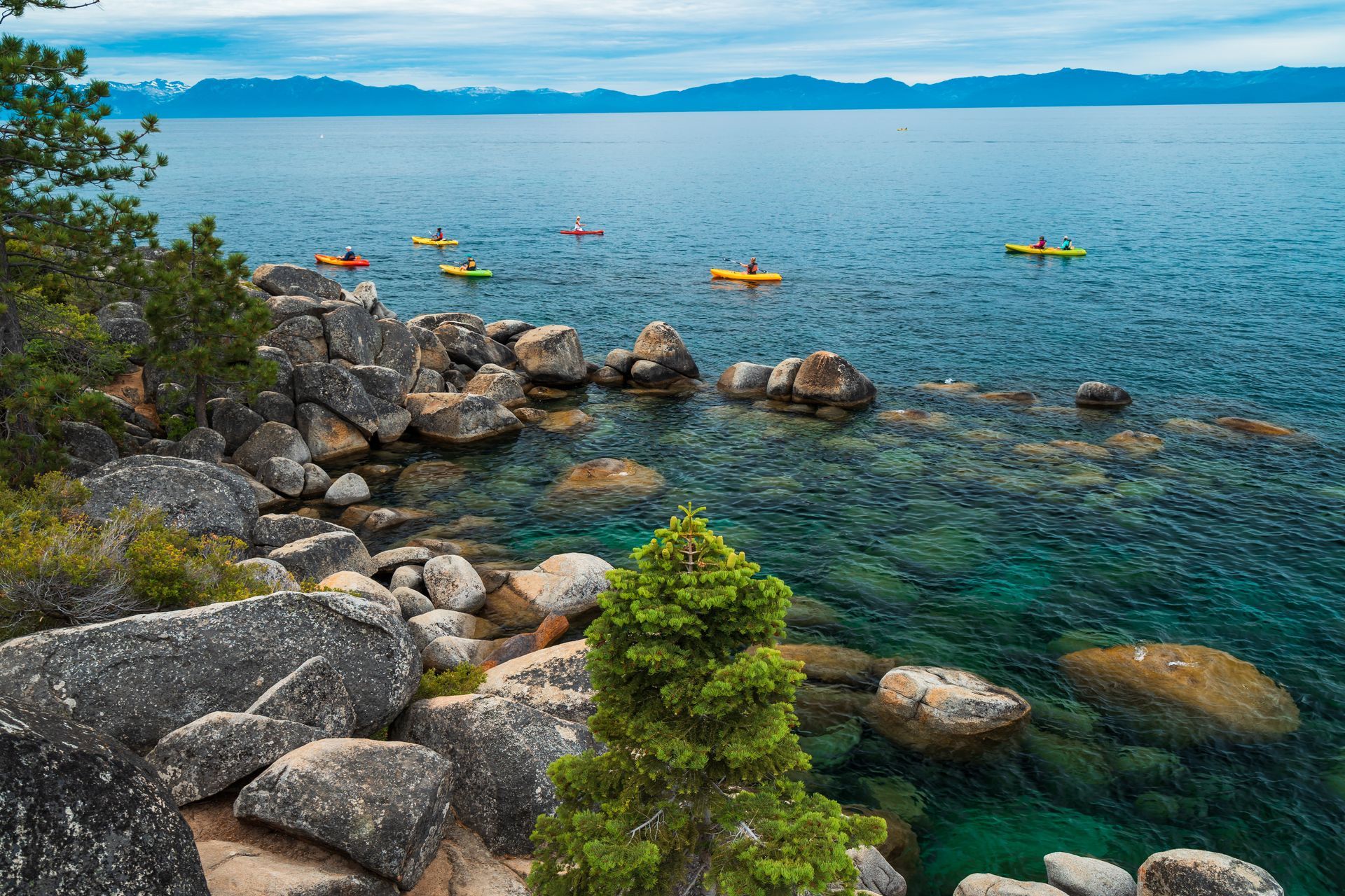 A group of people are kayaking on a lake surrounded by rocks.