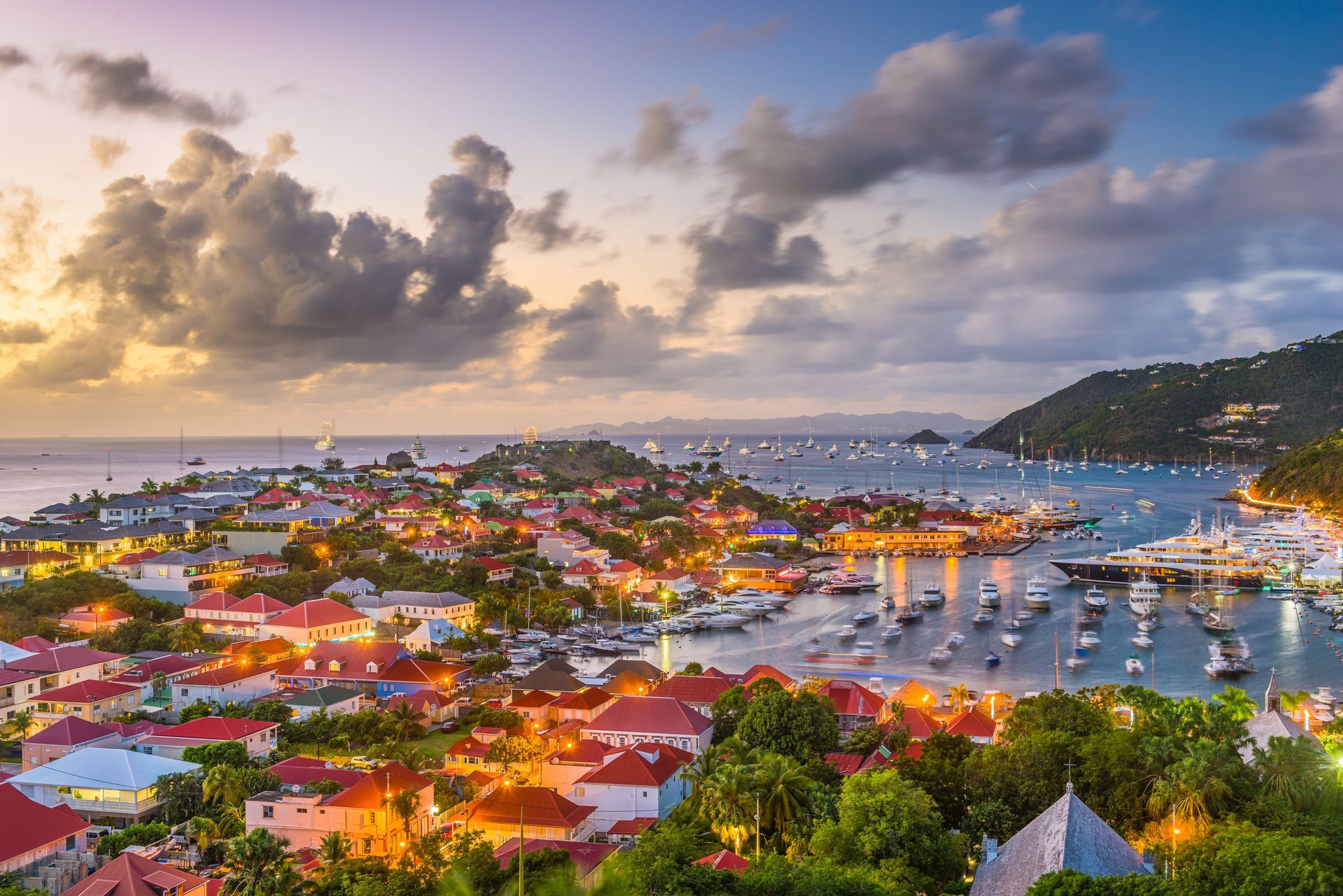 An aerial view of a city with boats in the water at sunset.