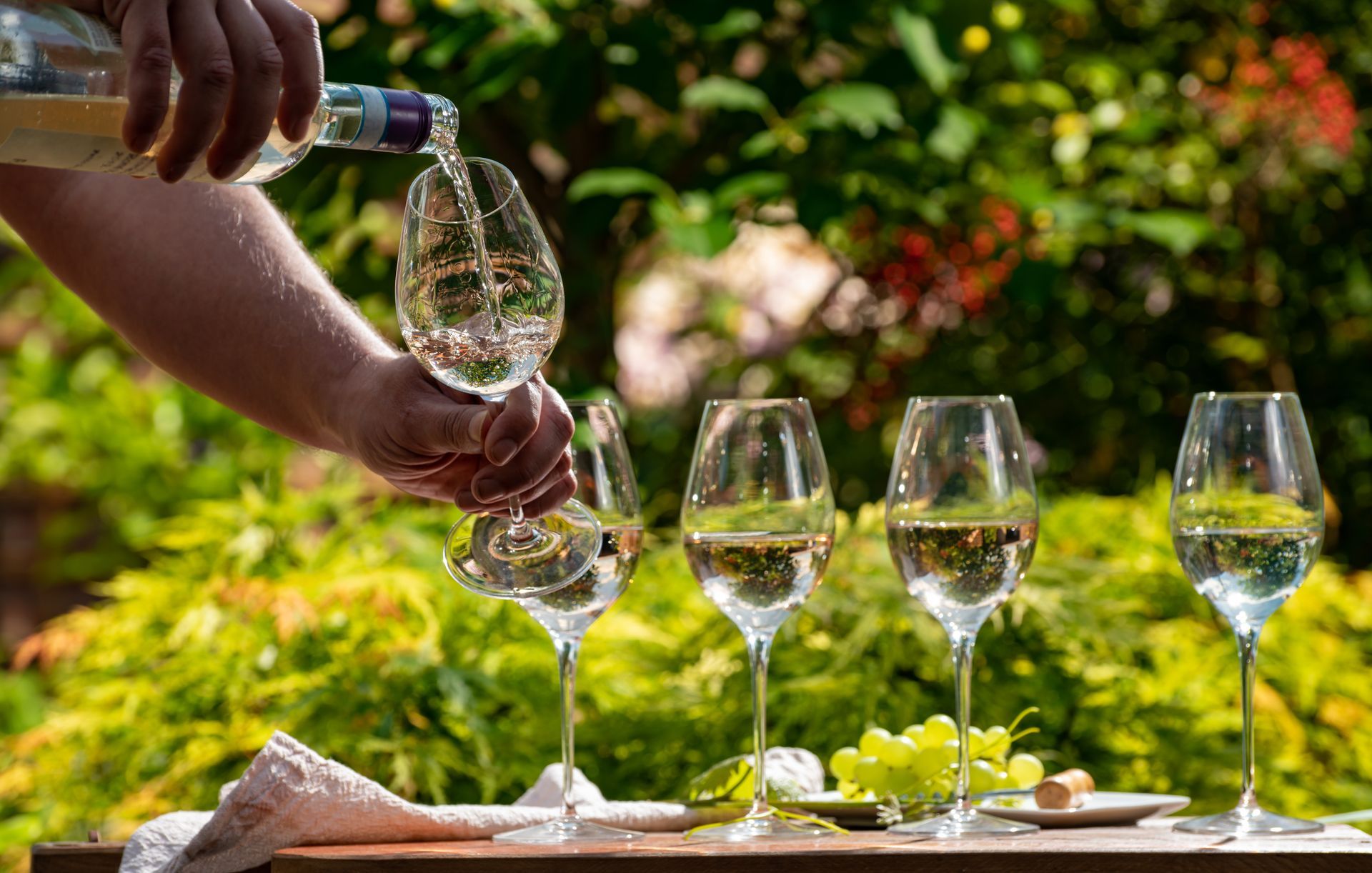 A person is pouring wine into a glass on a table.