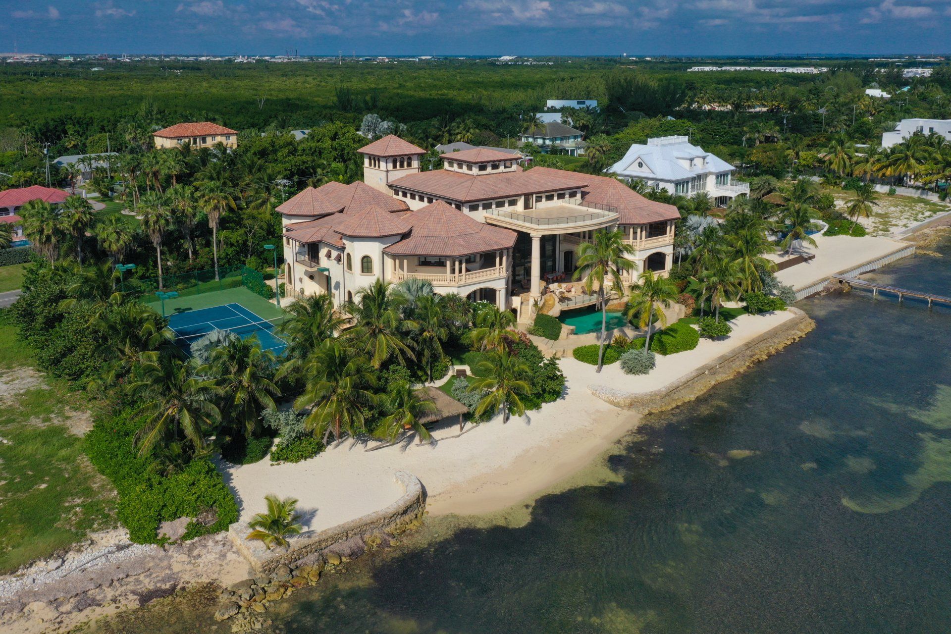 an aerial view of a large house on a beach next to the ocean