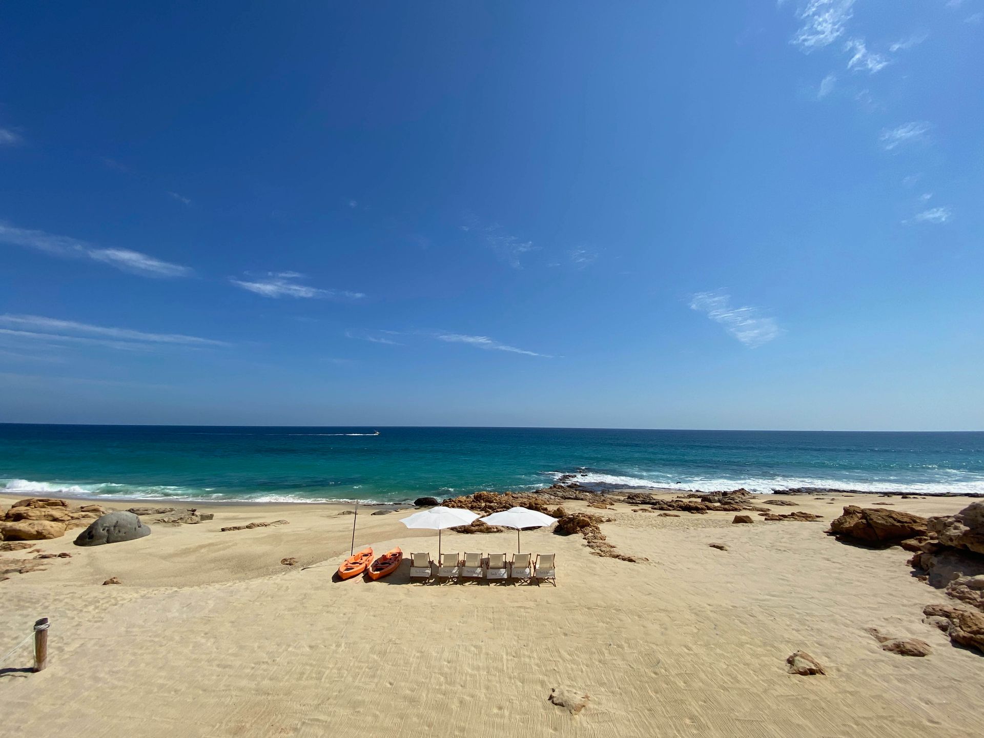 a sandy beach with umbrellas and chairs near the ocean