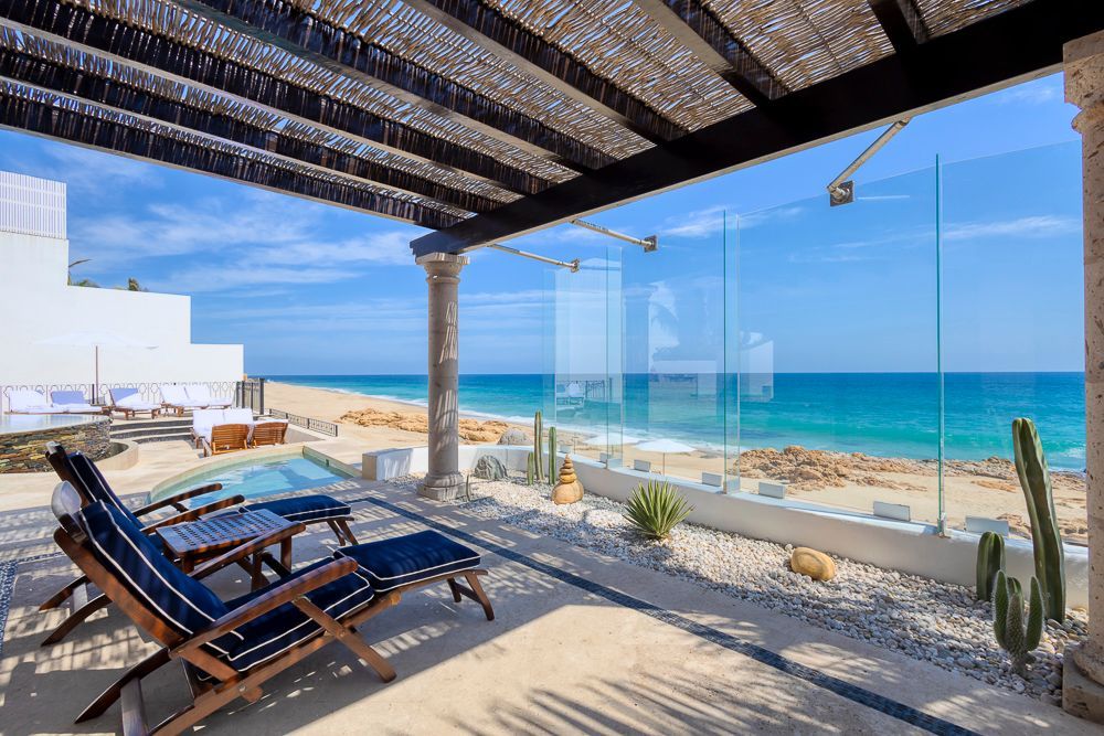 a patio with chairs and a view of the ocean