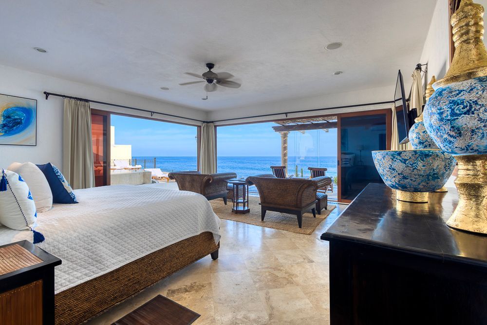 a bedroom with a large bed and a view of the ocean