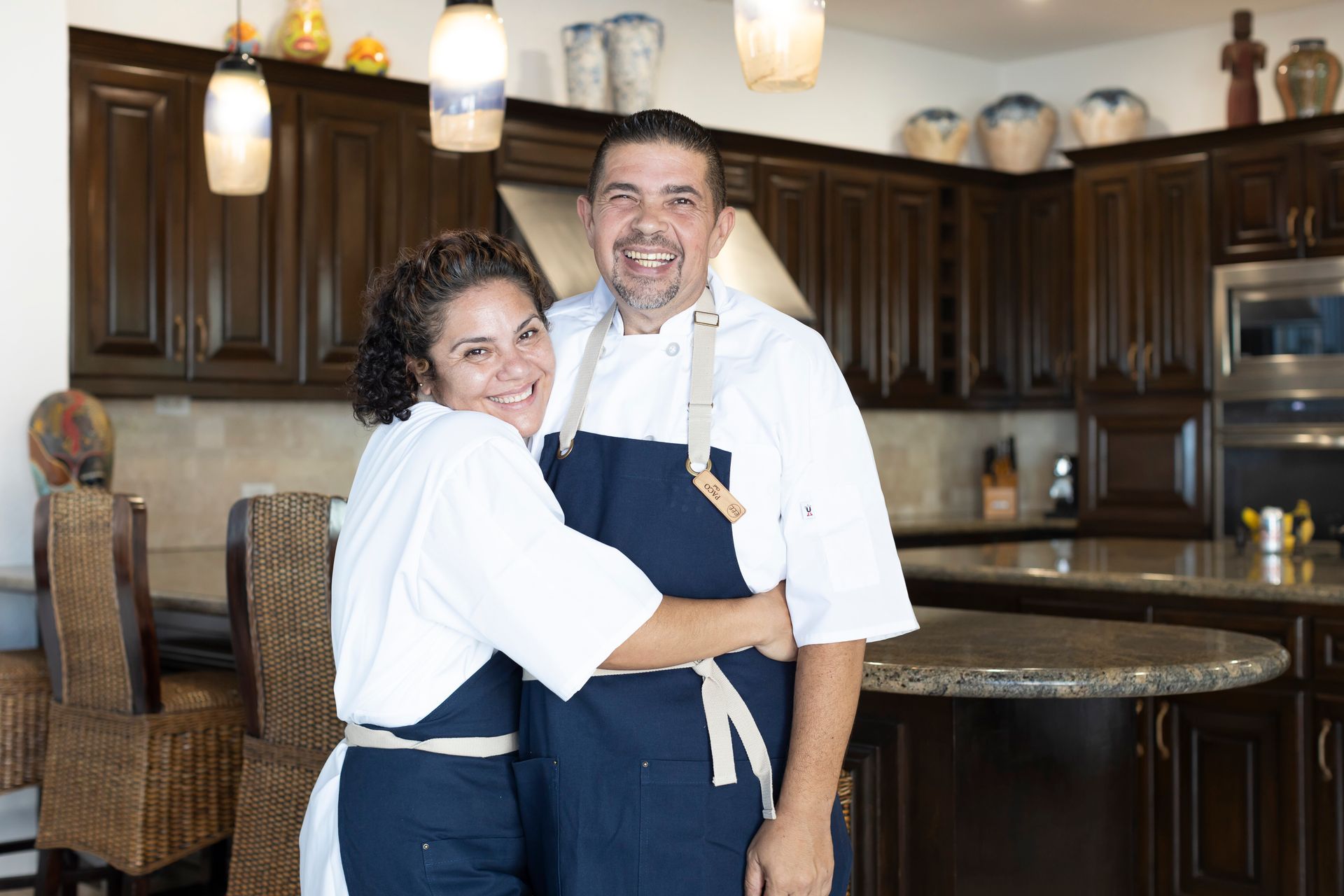 a man and a woman are posing for a picture in a kitchen