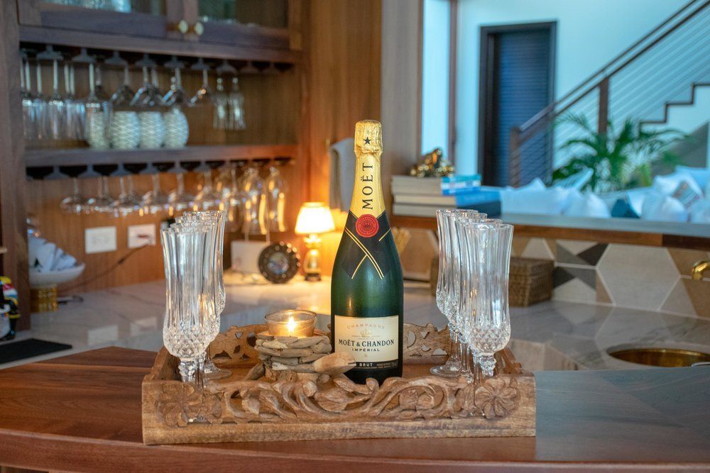 a bottle of champagne is sitting on a wooden tray with two glasses
