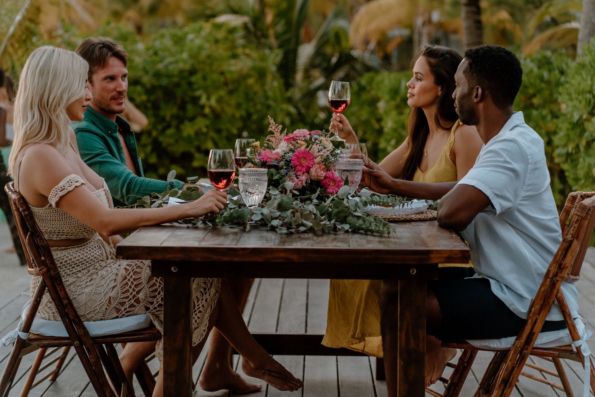 a group of people are sitting at a table drinking wine