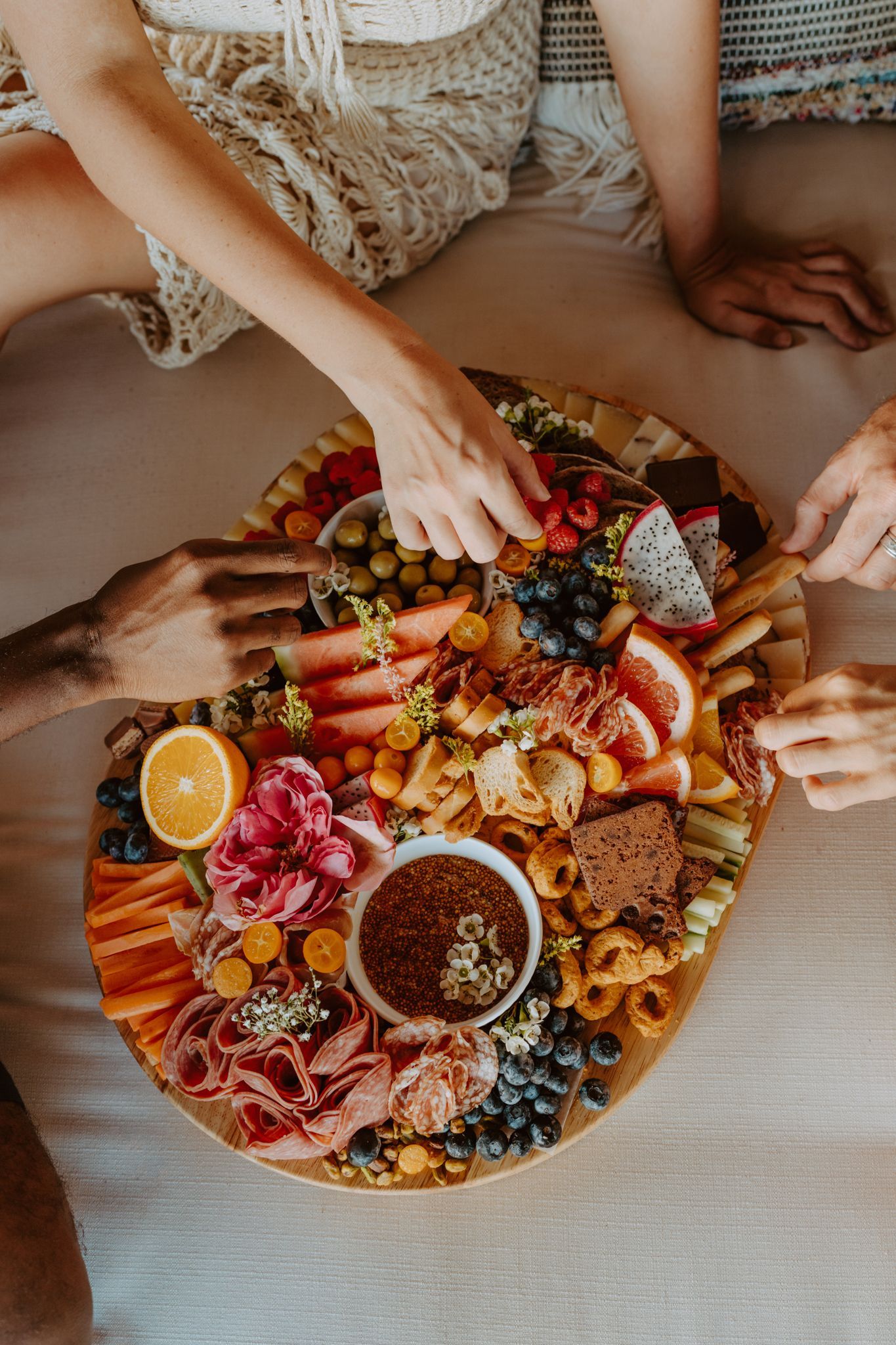 a group of people are sitting around a large platter of food
