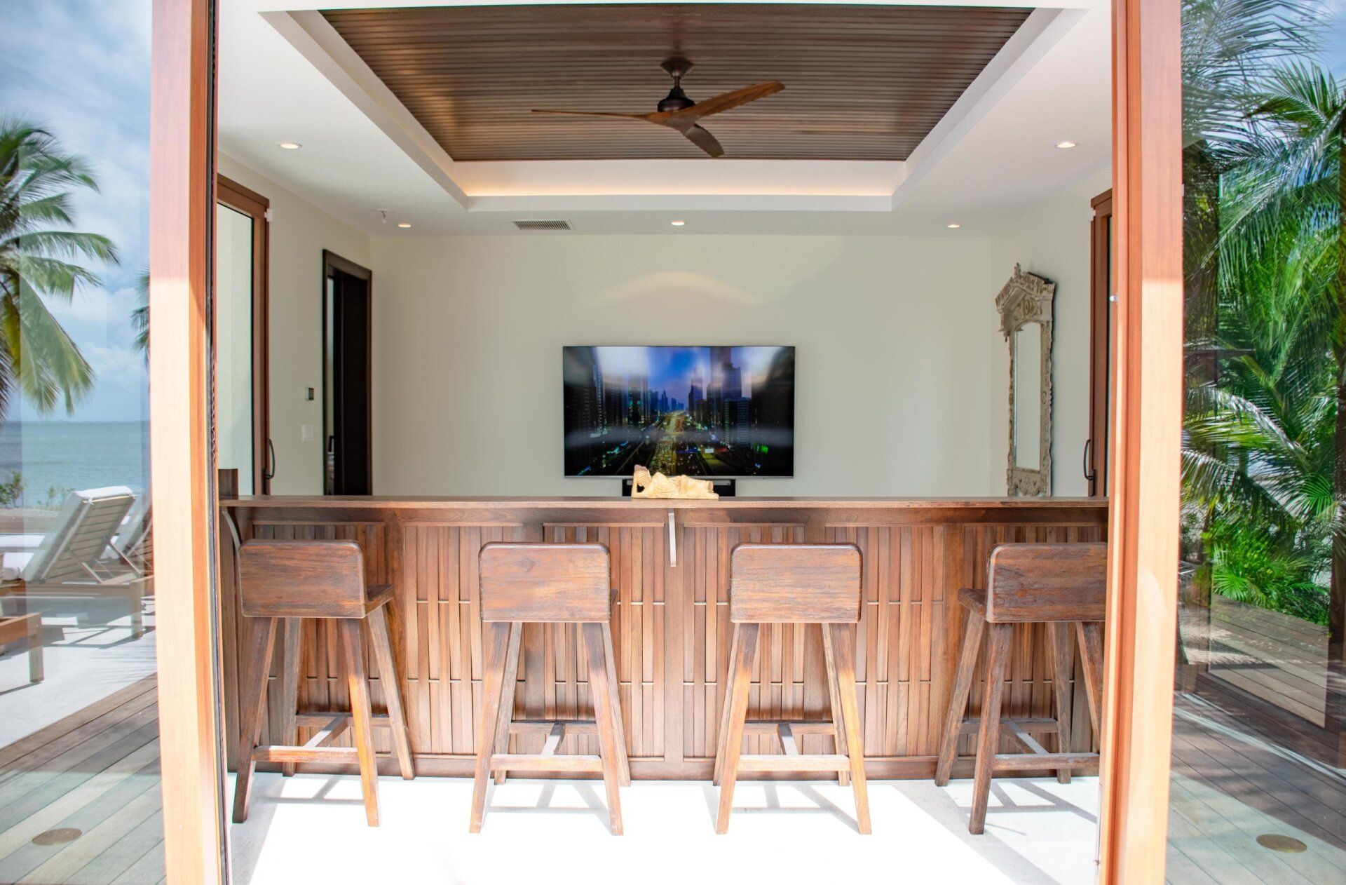 a bar with stools and a flat screen tv on the wall
