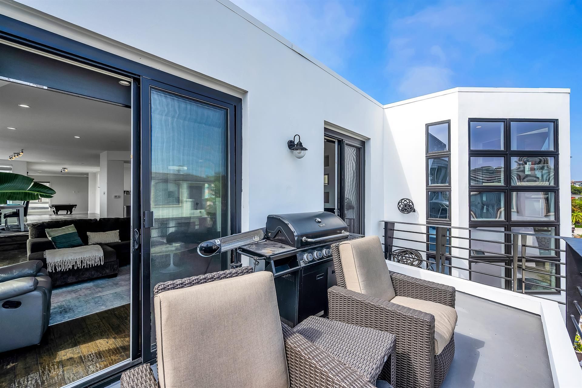 A balcony with chairs and a grill in a house