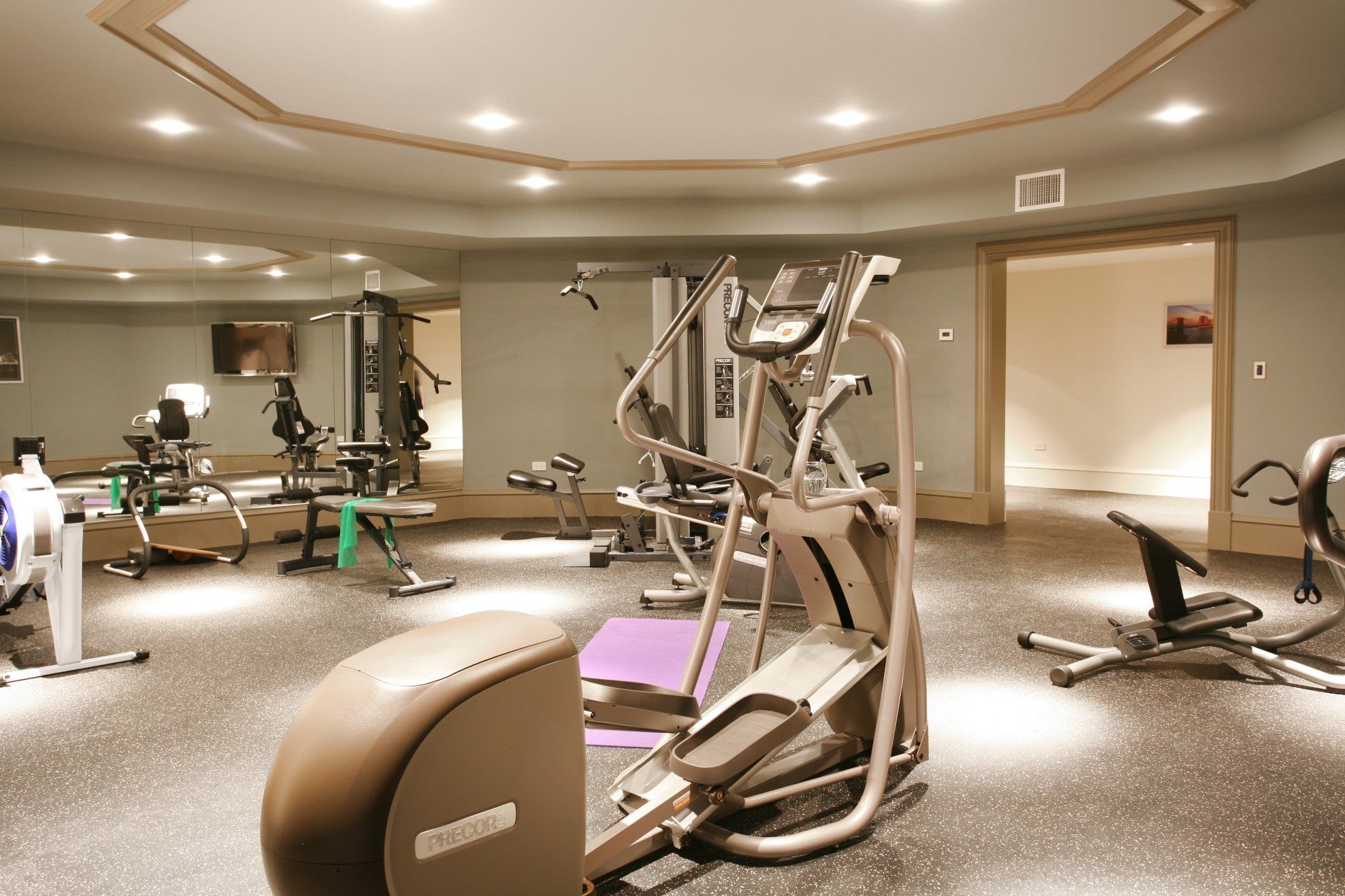 a gym with a lot of equipment including an elliptical