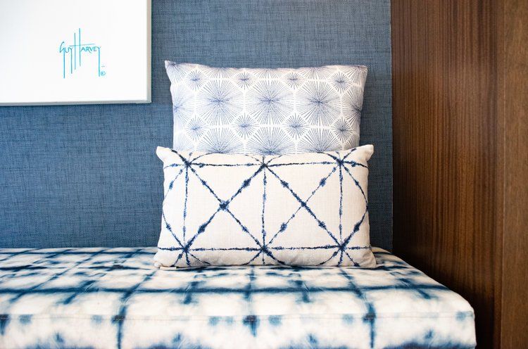 two pillows are sitting on a bench in a room with a blue wall