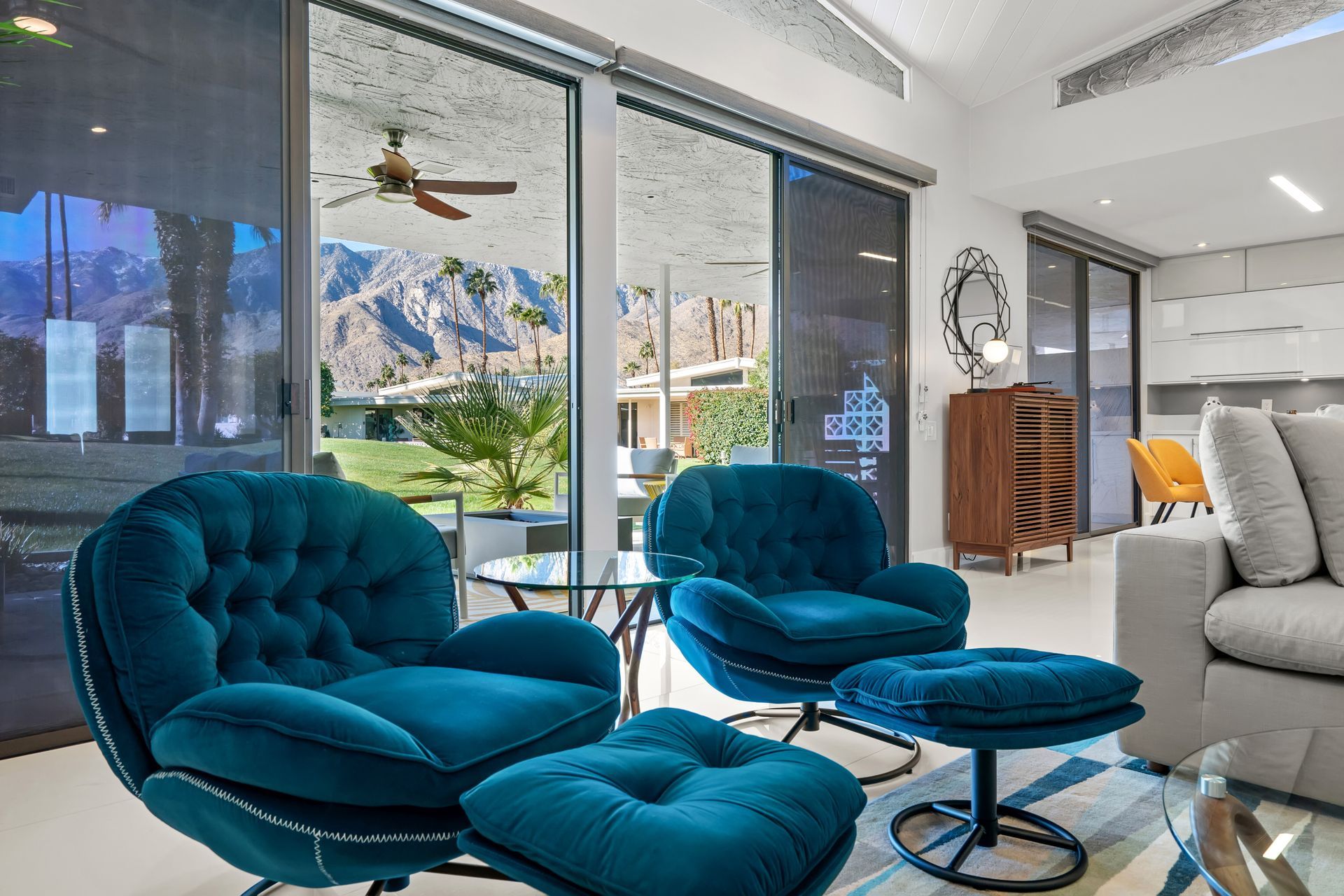 a living room with two blue chairs and an ottoman
