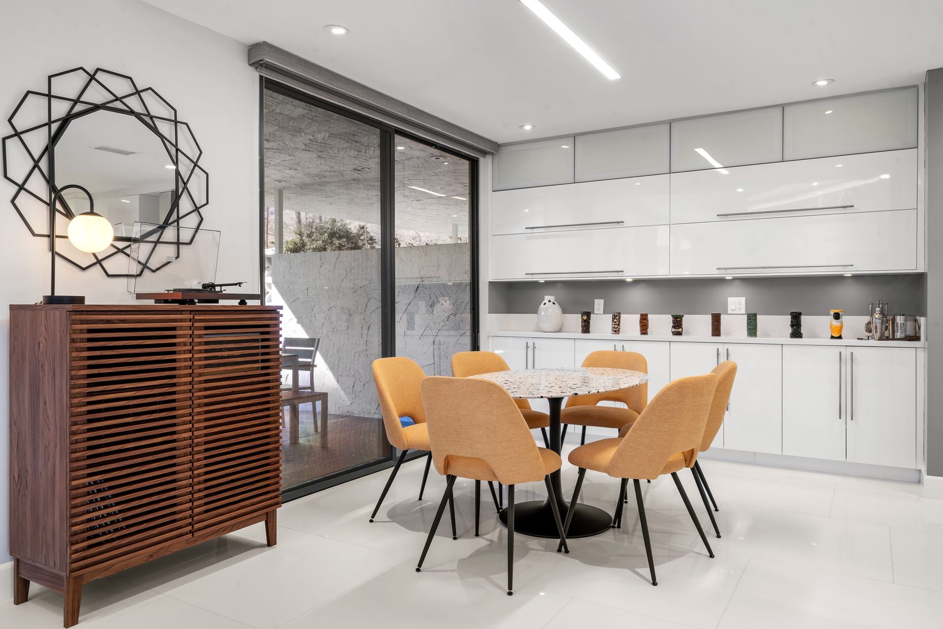 a dining room with a table and chairs and a mirror