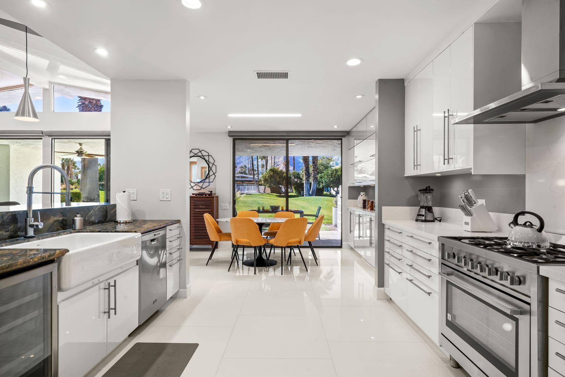 a kitchen with white cabinets and stainless steel appliances and a dining room in the background