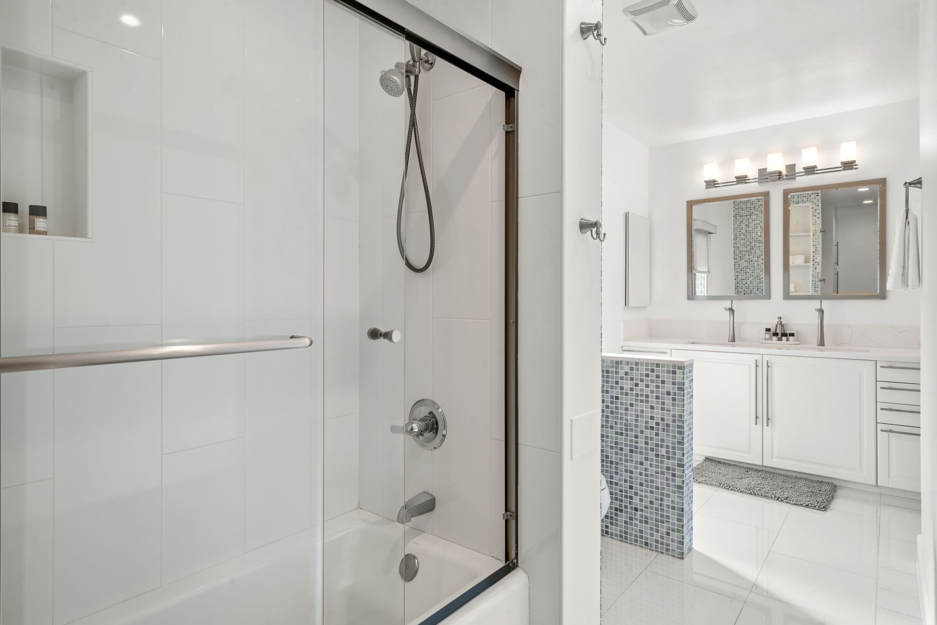 a bathroom with a shower, tub, sink and mirrors