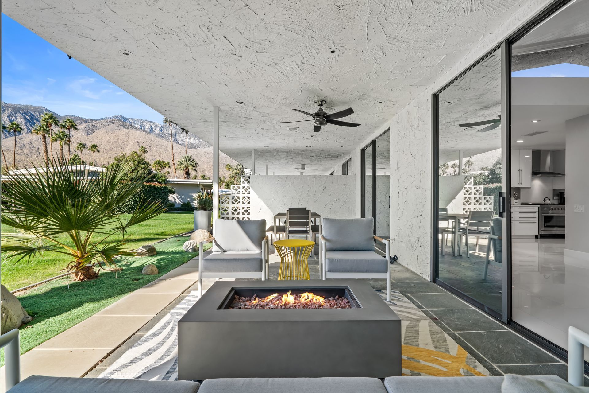 a patio with a fire pit and sliding glass doors