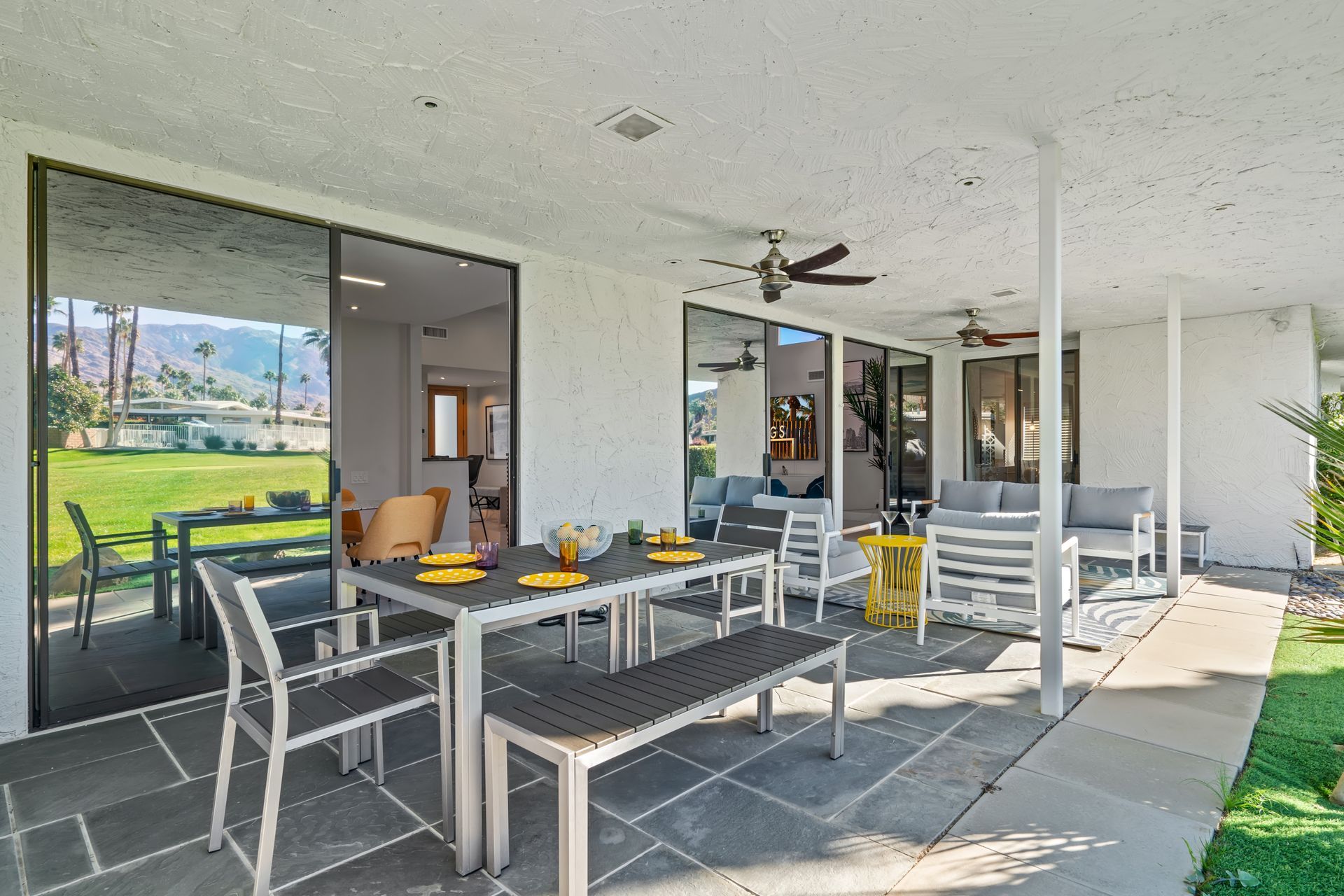 there is a table and chairs on the patio of a house