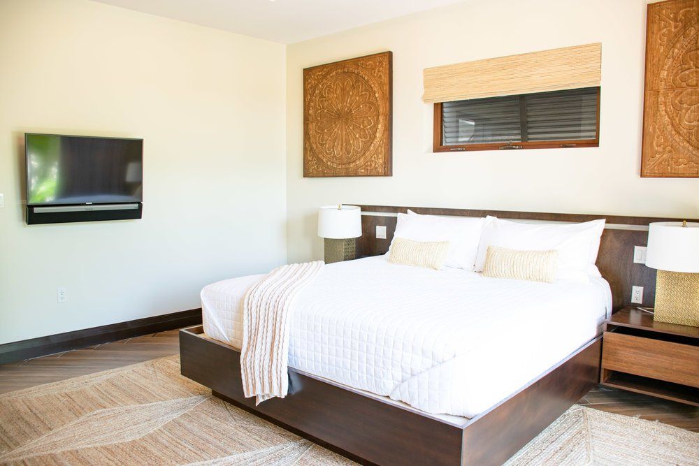 a bedroom with a large bed and a flat screen tv on the wall