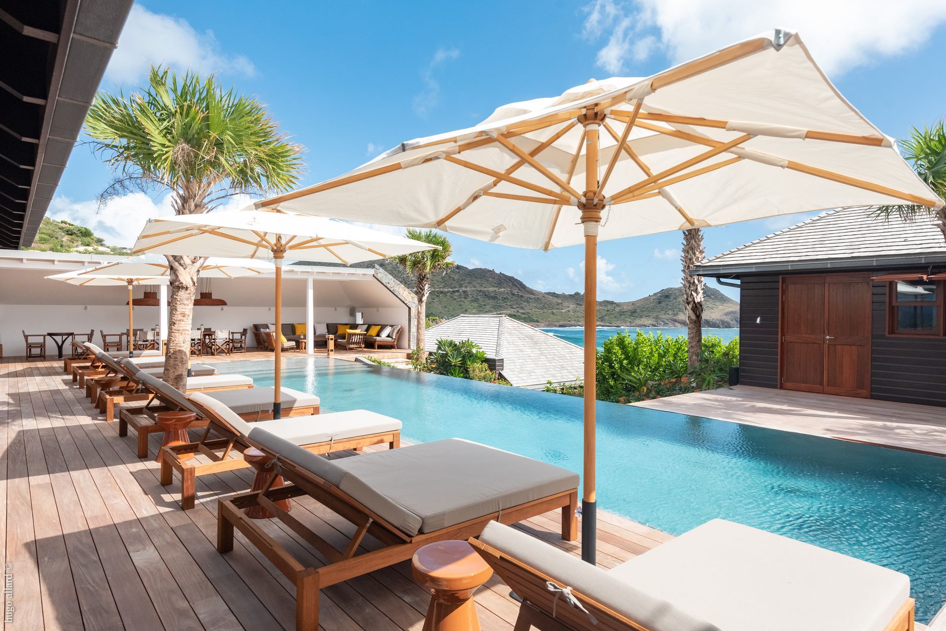 a swimming pool with umbrellas and lounge chairs around it