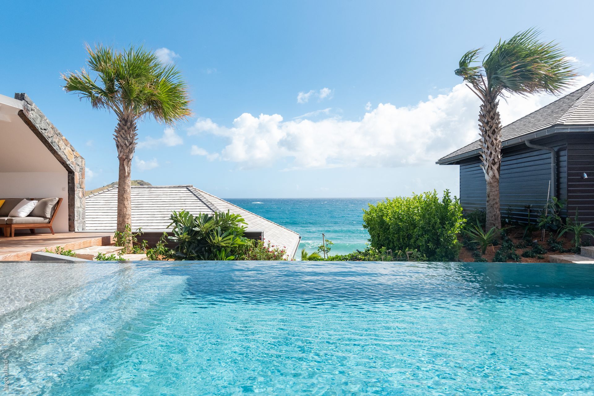 There is a swimming pool with a view of the ocean.