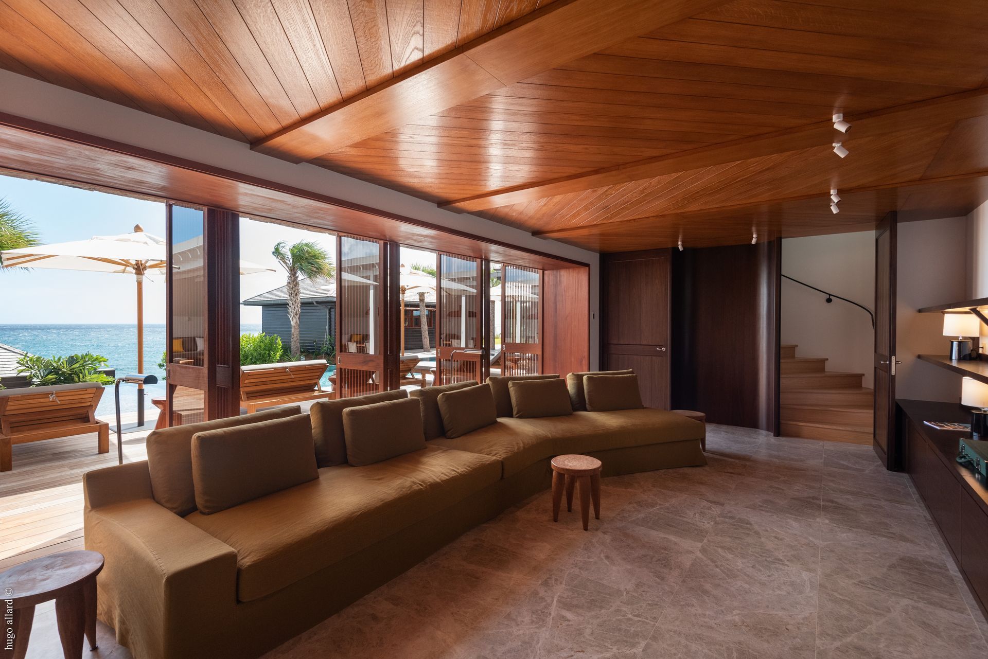 a living room with a large couch and a view of the ocean