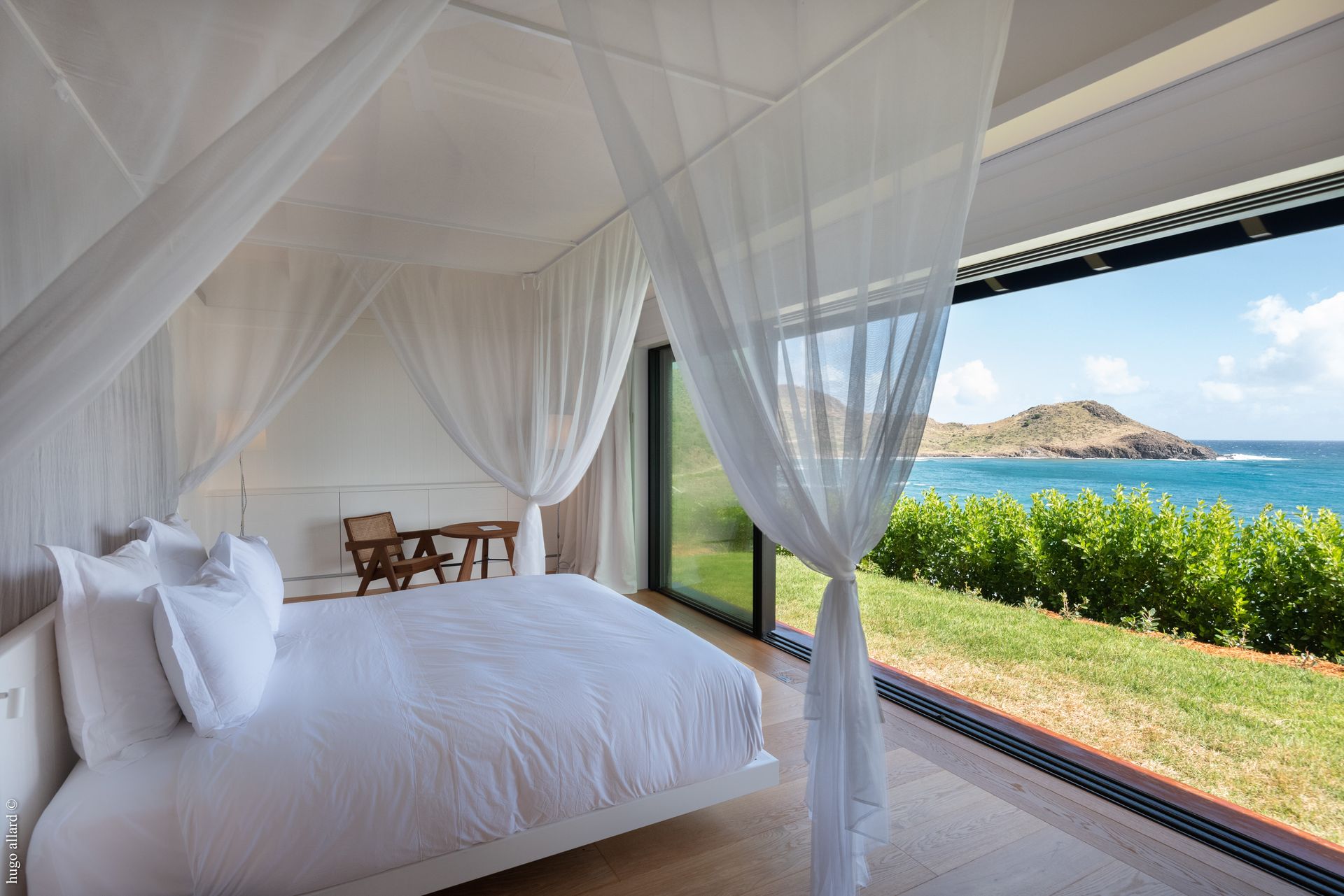 a bedroom with a canopy bed and a view of the ocean