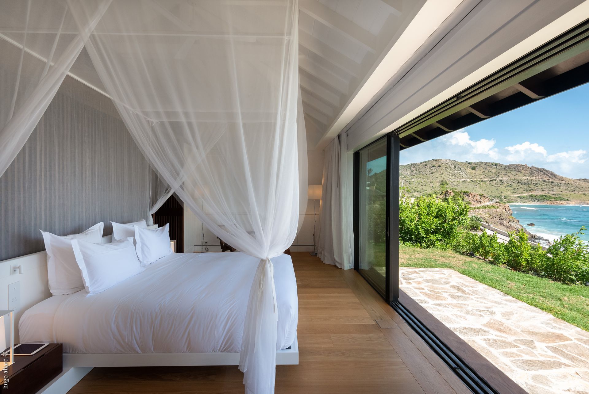 a bedroom with a canopy bed and a view of the ocean