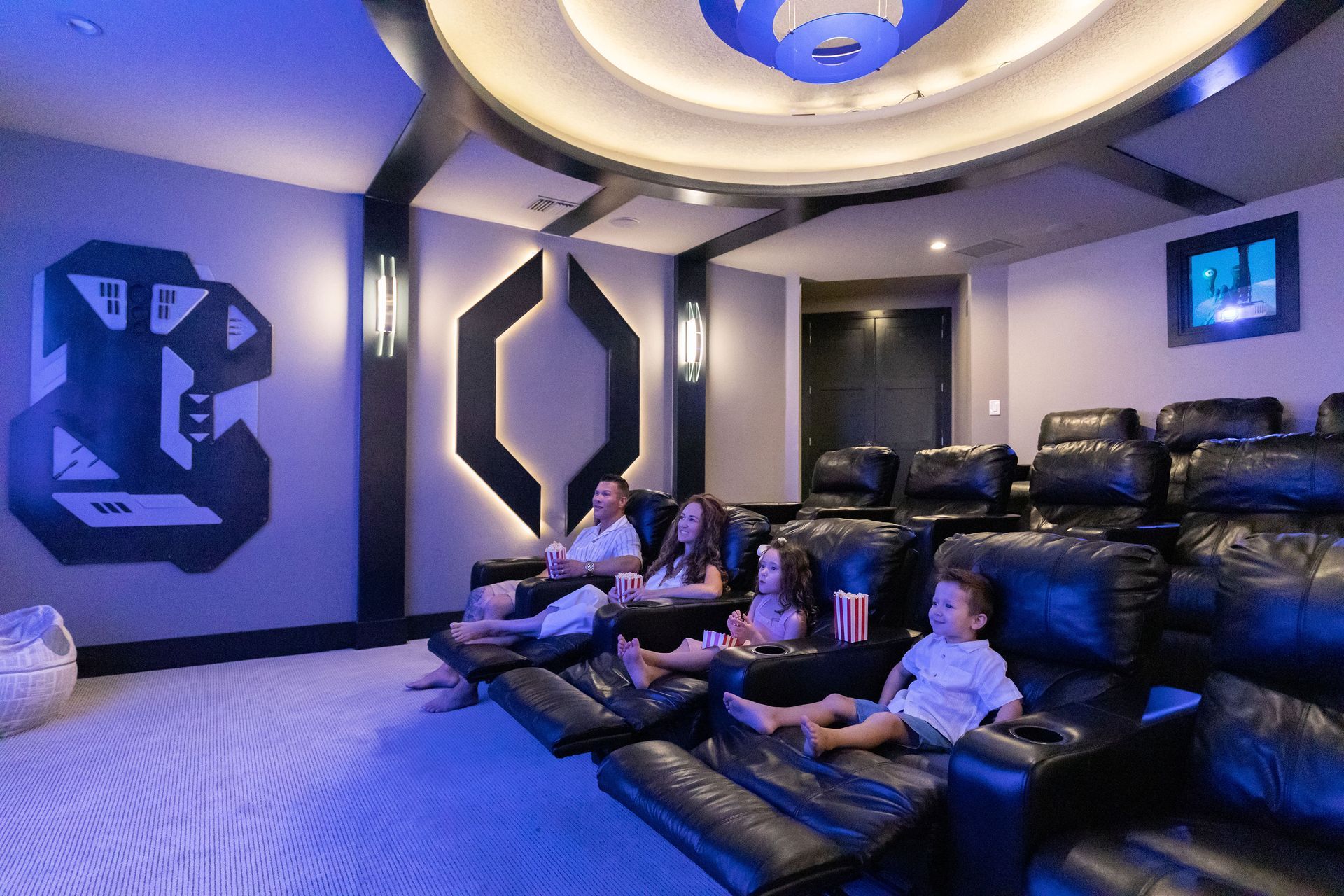 a family is sitting in a home theater watching a movie