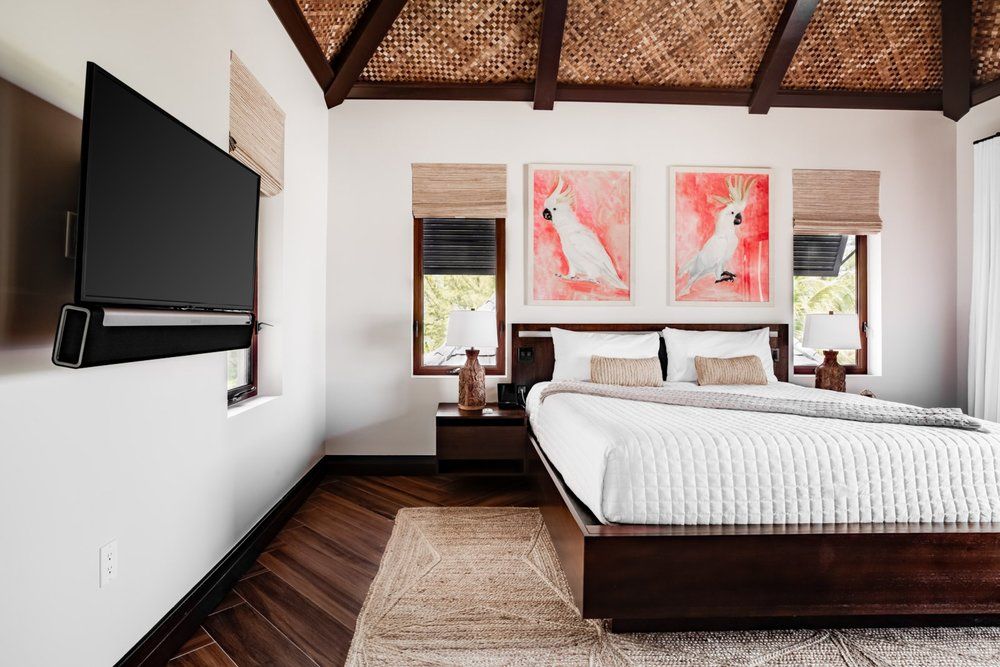 a bedroom with a large bed and a flat screen tv on the wall