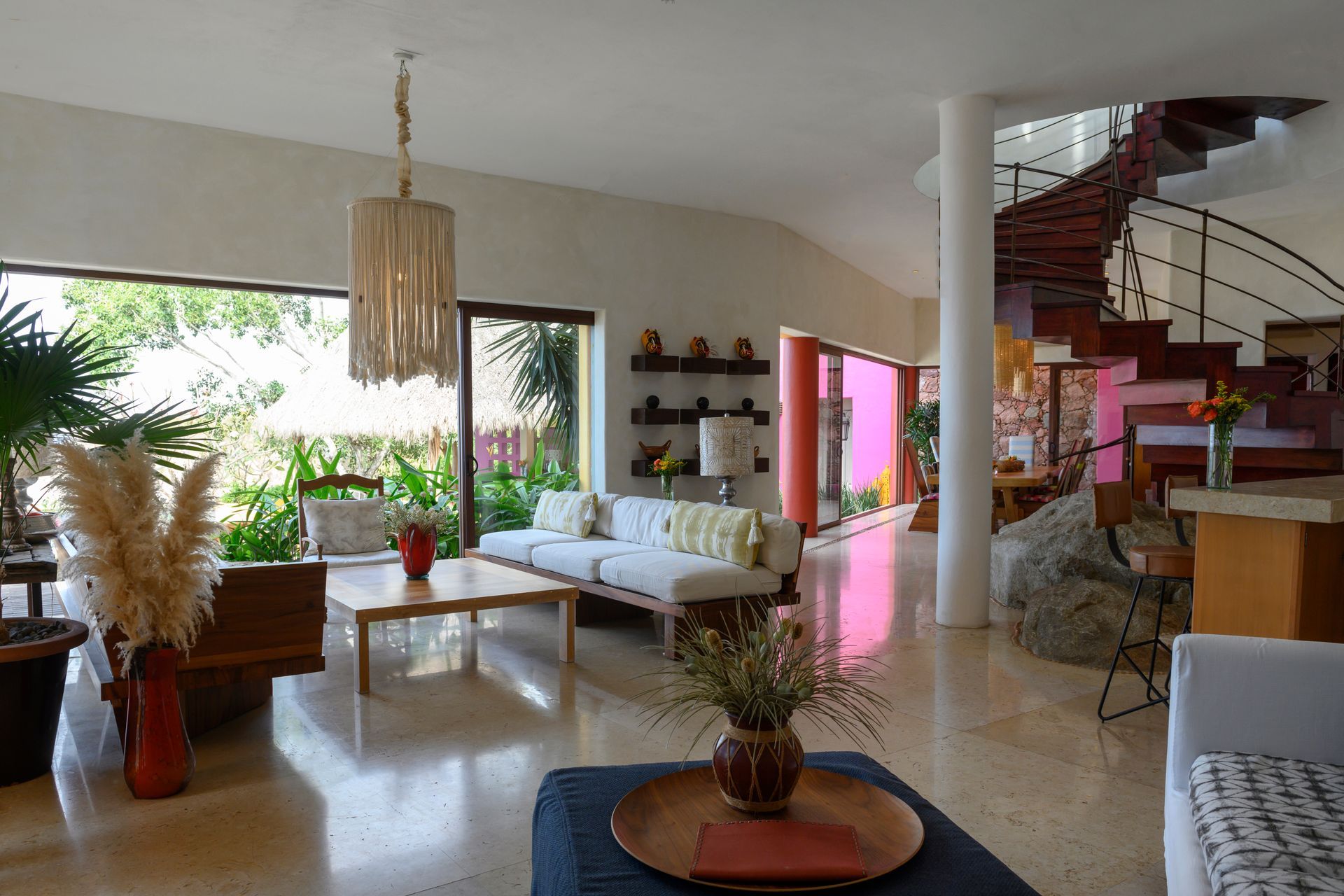 a living room with a couch, table, chairs and stairs