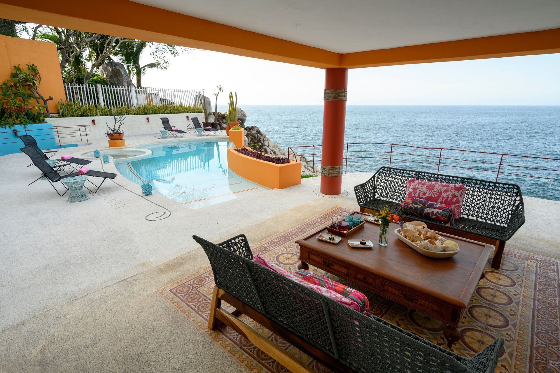 a patio with a couch and a table overlooking the ocean