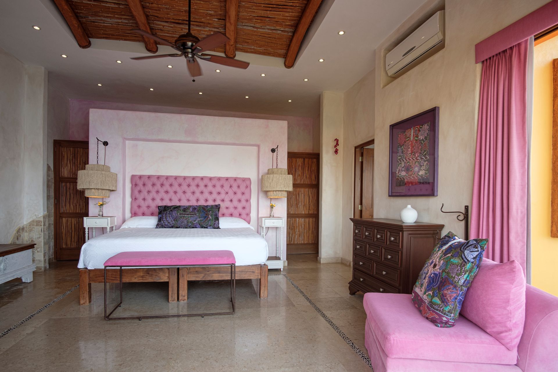 a large bedroom with a king size bed and a pink couch