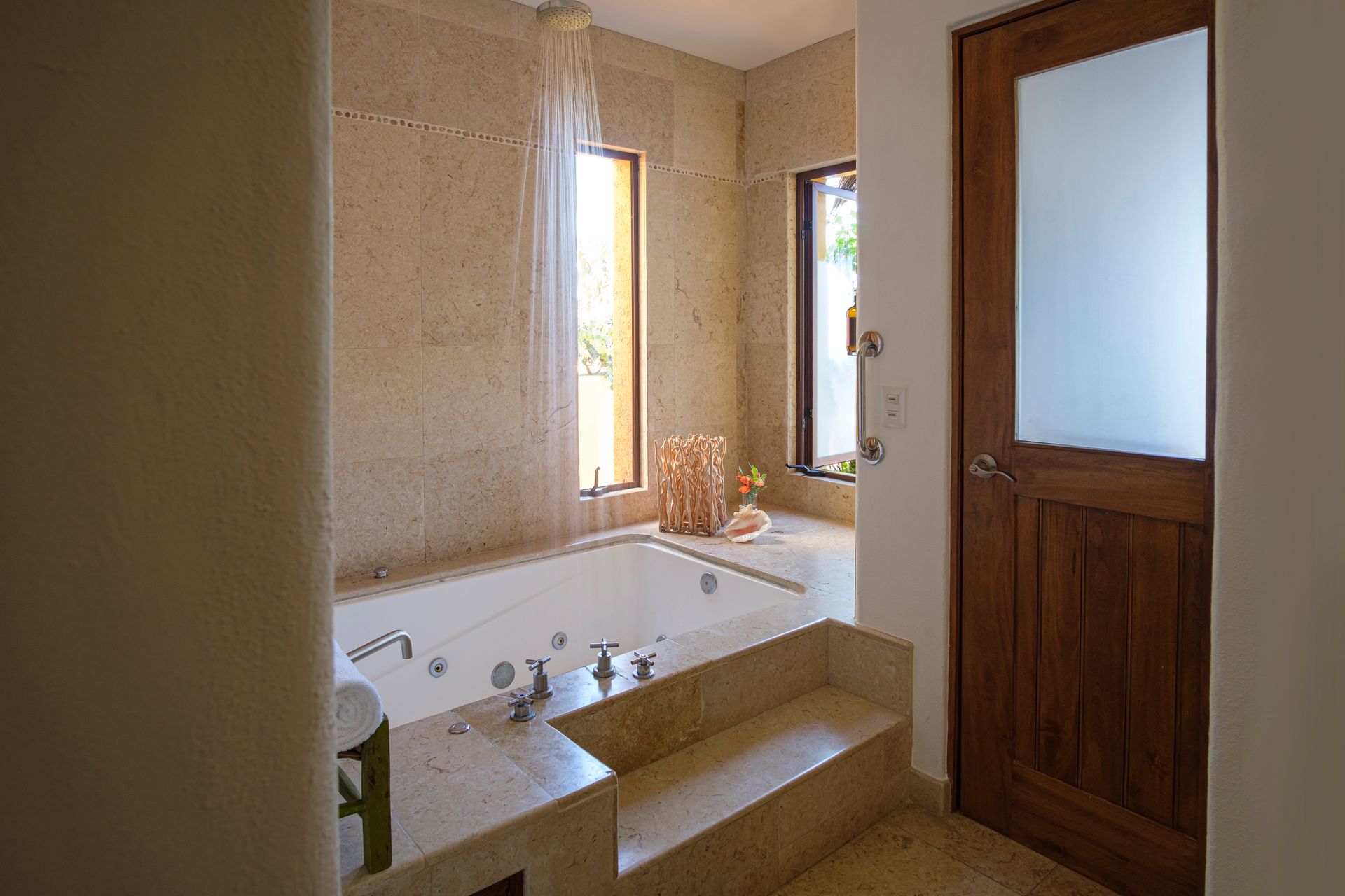 a bathroom with a jacuzzi tub and a wooden door