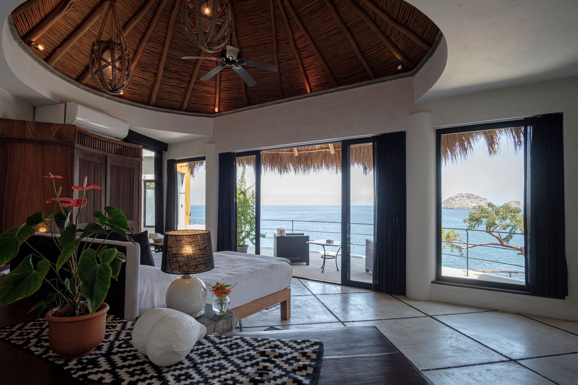a bedroom with a ceiling fan and a view of the ocean