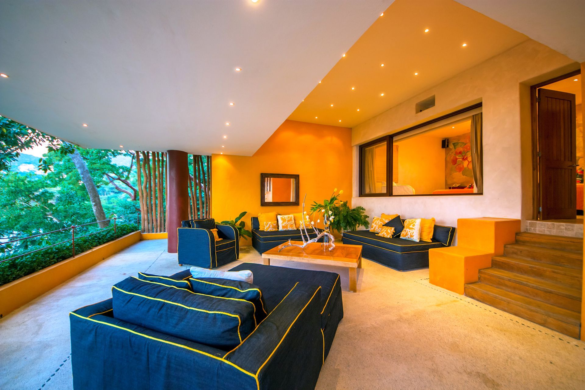 a living room with yellow walls and blue furniture