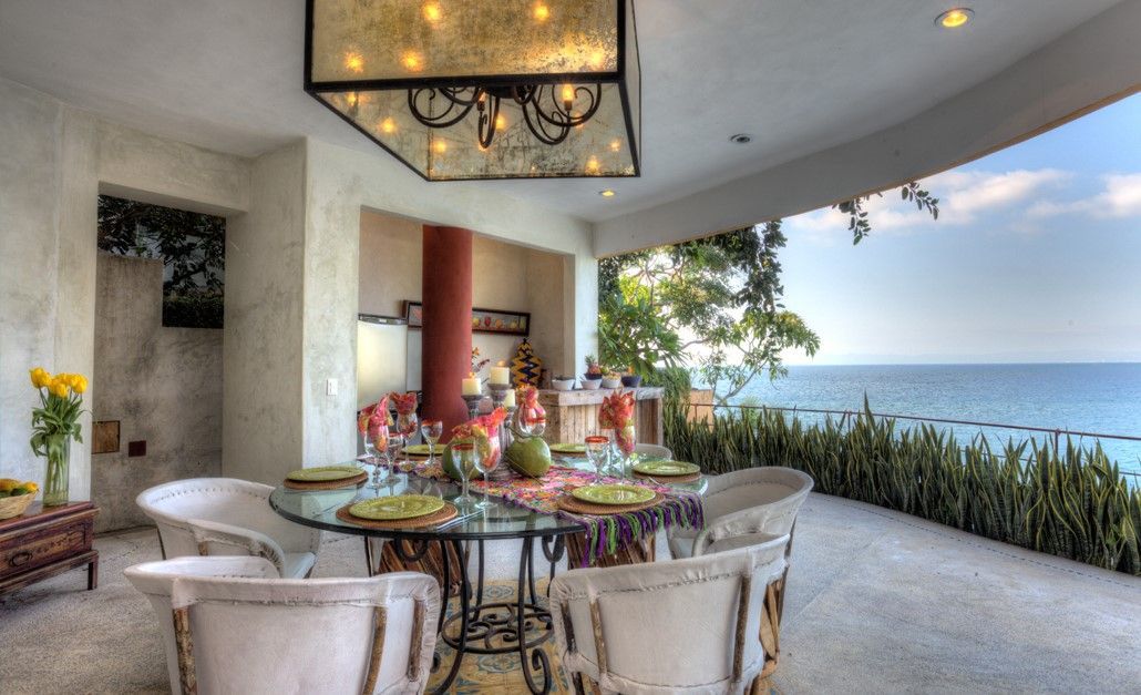 a dining room with a table and chairs overlooking the ocean
