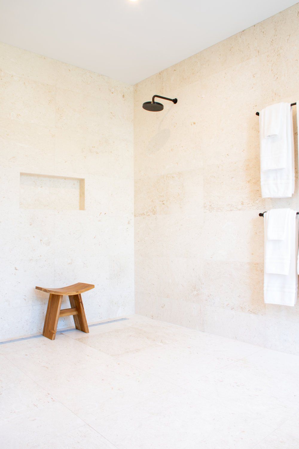 a bathroom with a shower and a wooden bench