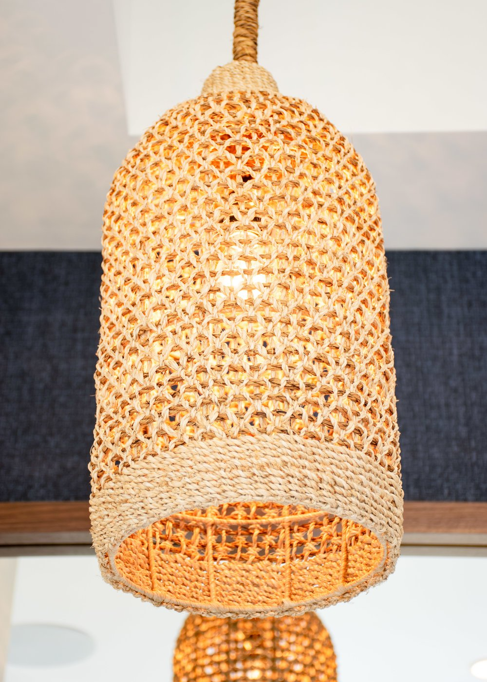 a close up of a wicker lamp hanging from the ceiling
