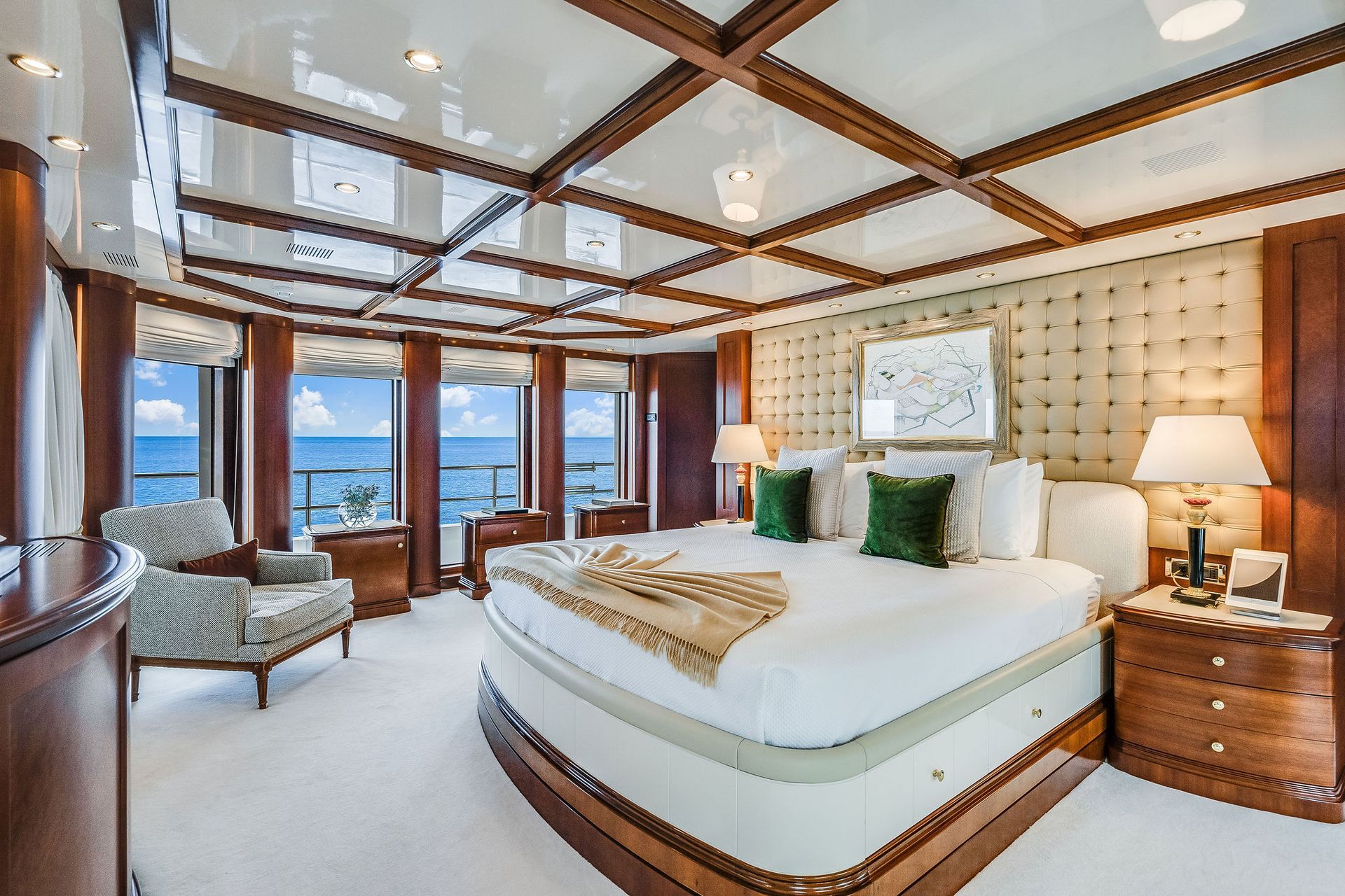 a bedroom on a yacht with a large bed and lots of windows overlooking the ocean