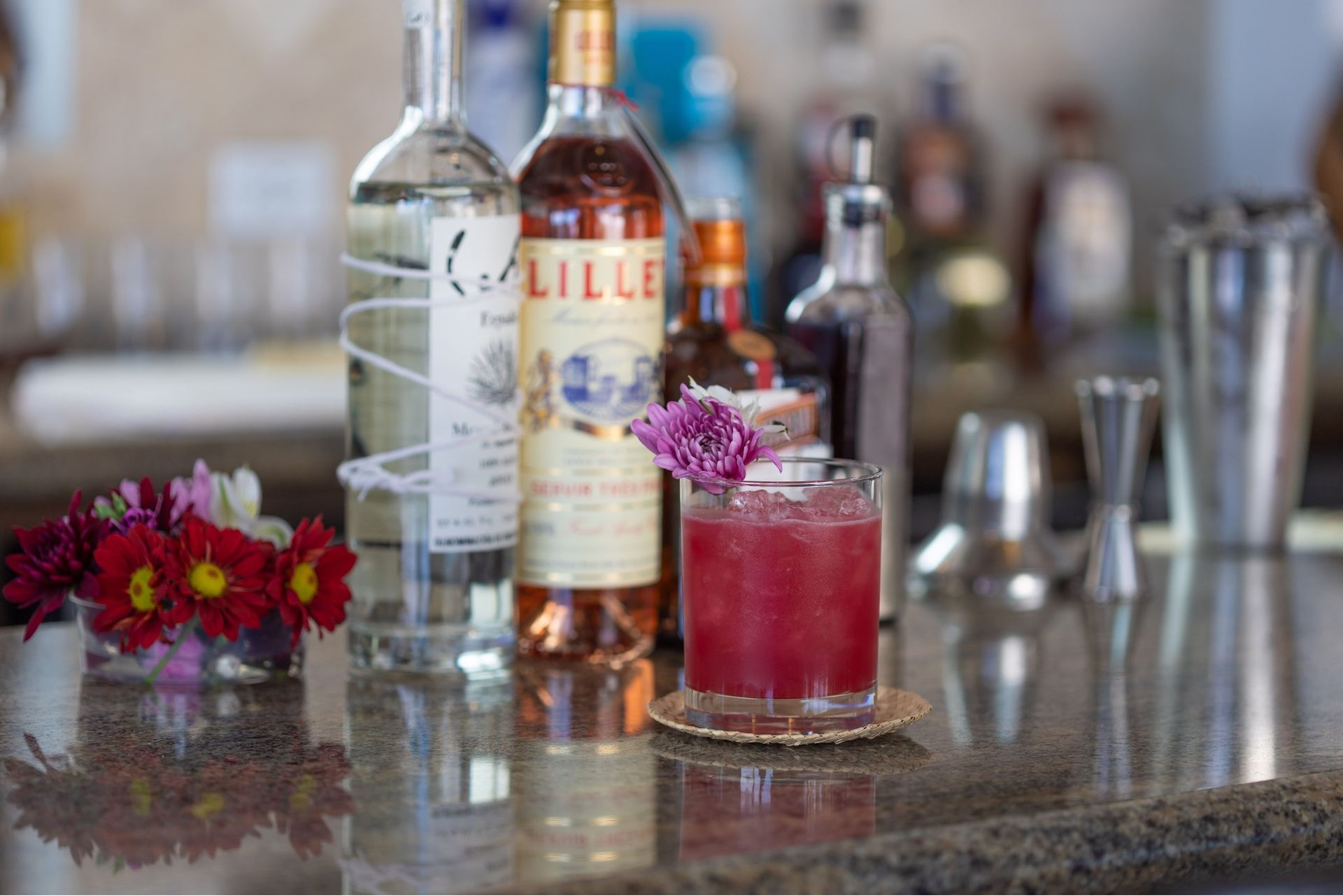 A bar with bottles of liquor and a drink on the counter.