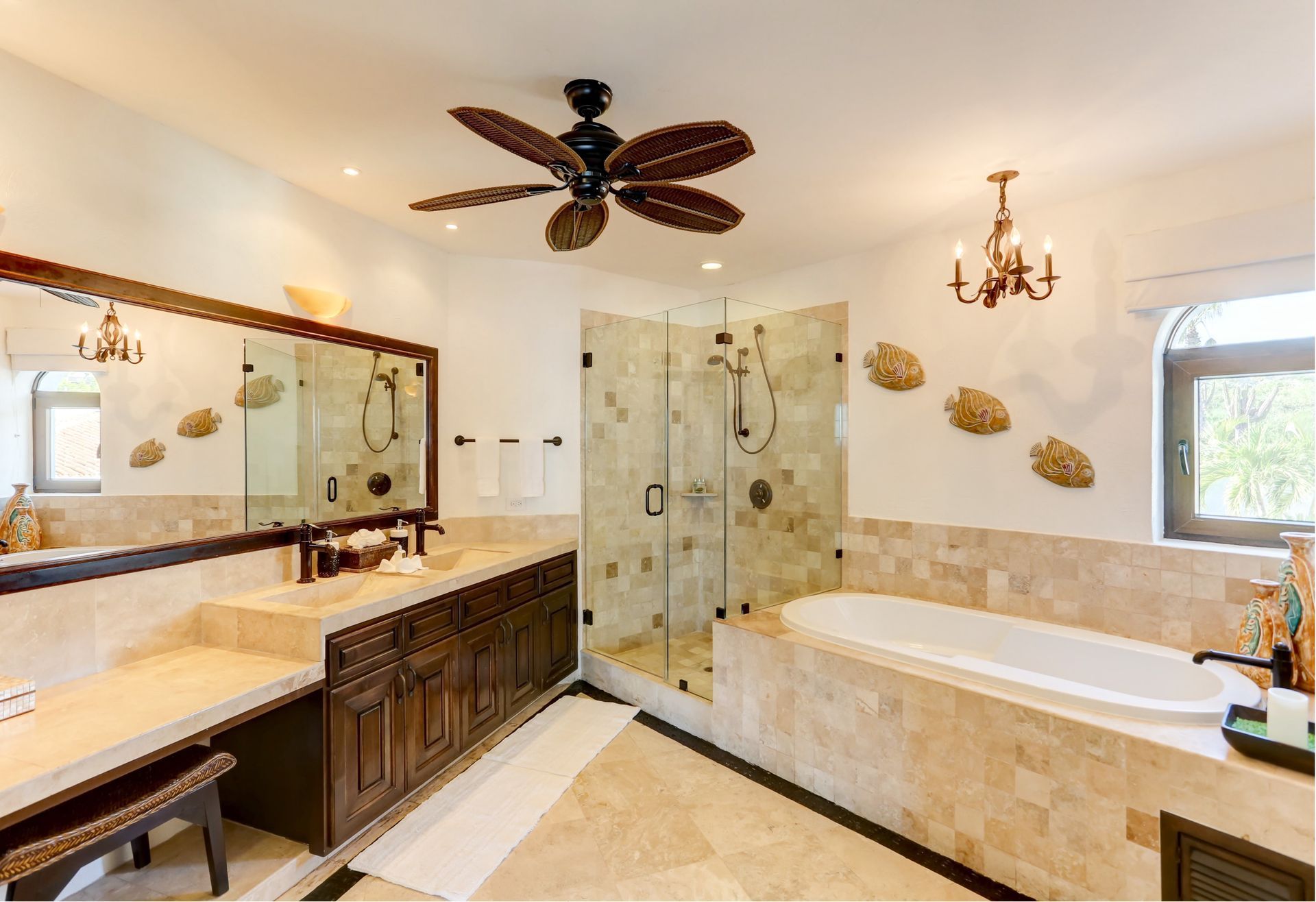 a bathroom with two sinks, a tub, a shower and a ceiling fan