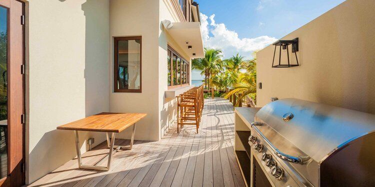 a grill is sitting on a wooden deck next to a table